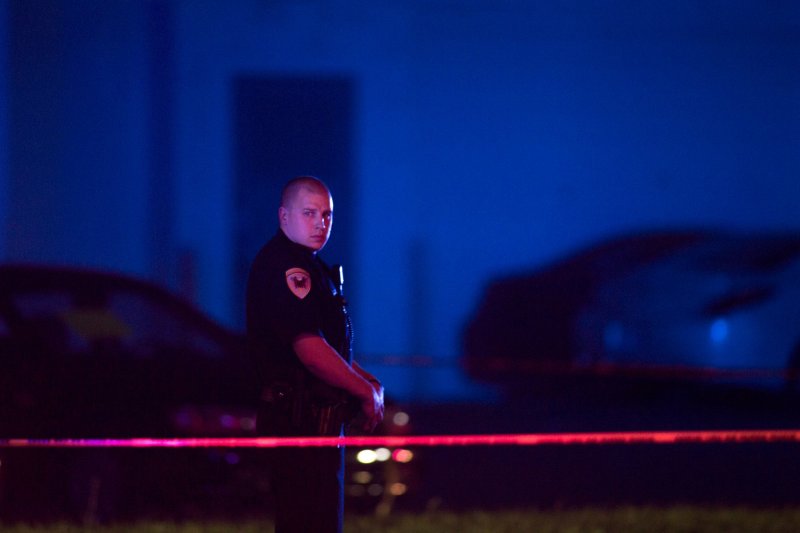 In this Sept. 7, 2016 photo, a police officer guards the scene after a police officer fatally shot a man who was suspected of stealing a semi-automatic pistol from a gun store in Wyoming, Mich., in the suburbs of Grand Rapids. Community leaders in Grand Rapids say the police can only do so much. They're looking for more proactive measures as opposed to reactive ones.