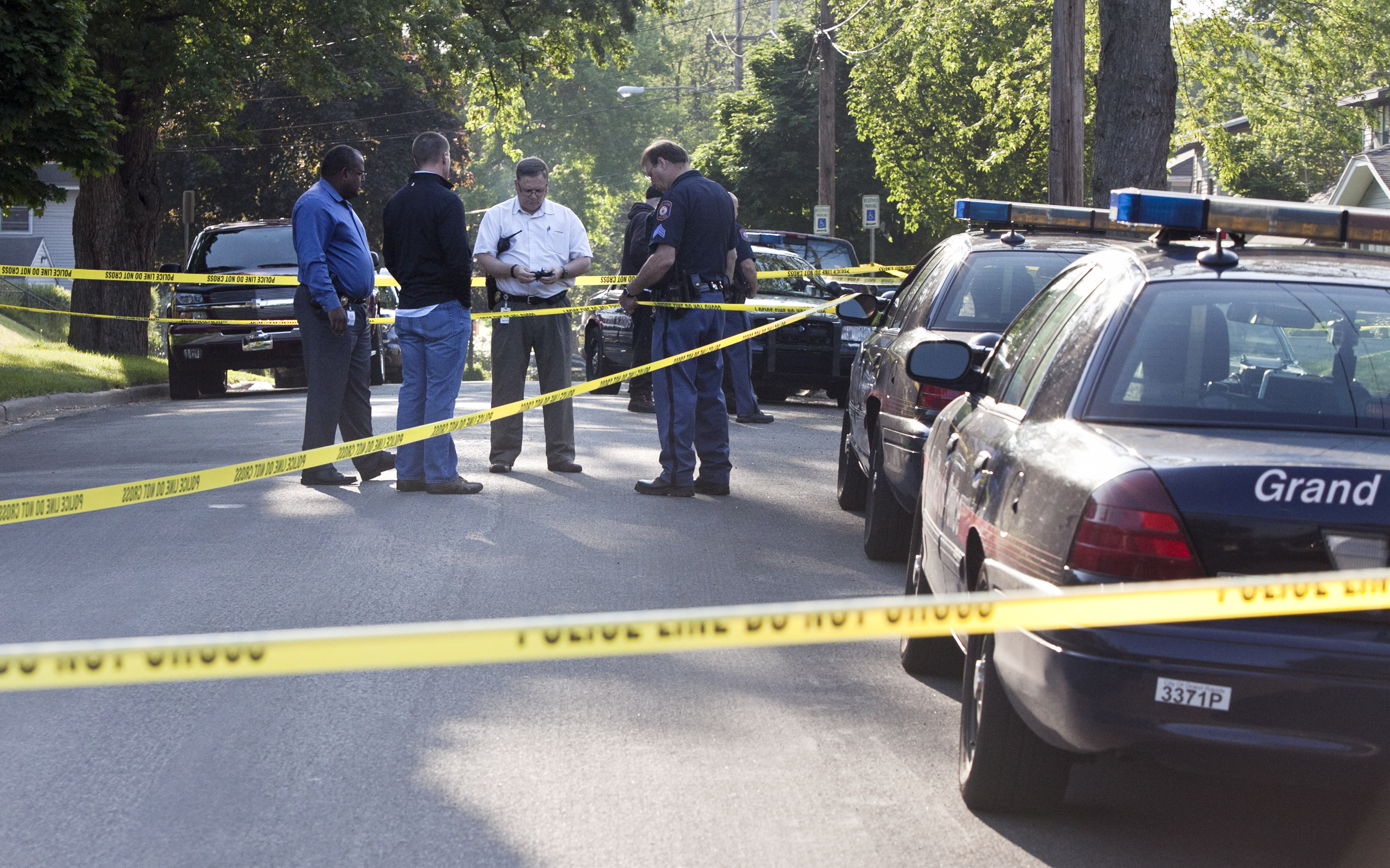 Police investigate the scene of a shooting, on May 28, 2015 in Grand Rapids, Mich. As people across the country call for more investment in inner-city communities, activists in Grand Rapids are turning to crowdsourcing to help them fund anti-violence initiatives. (Cory Morse—Grand Rapids Press/AP)