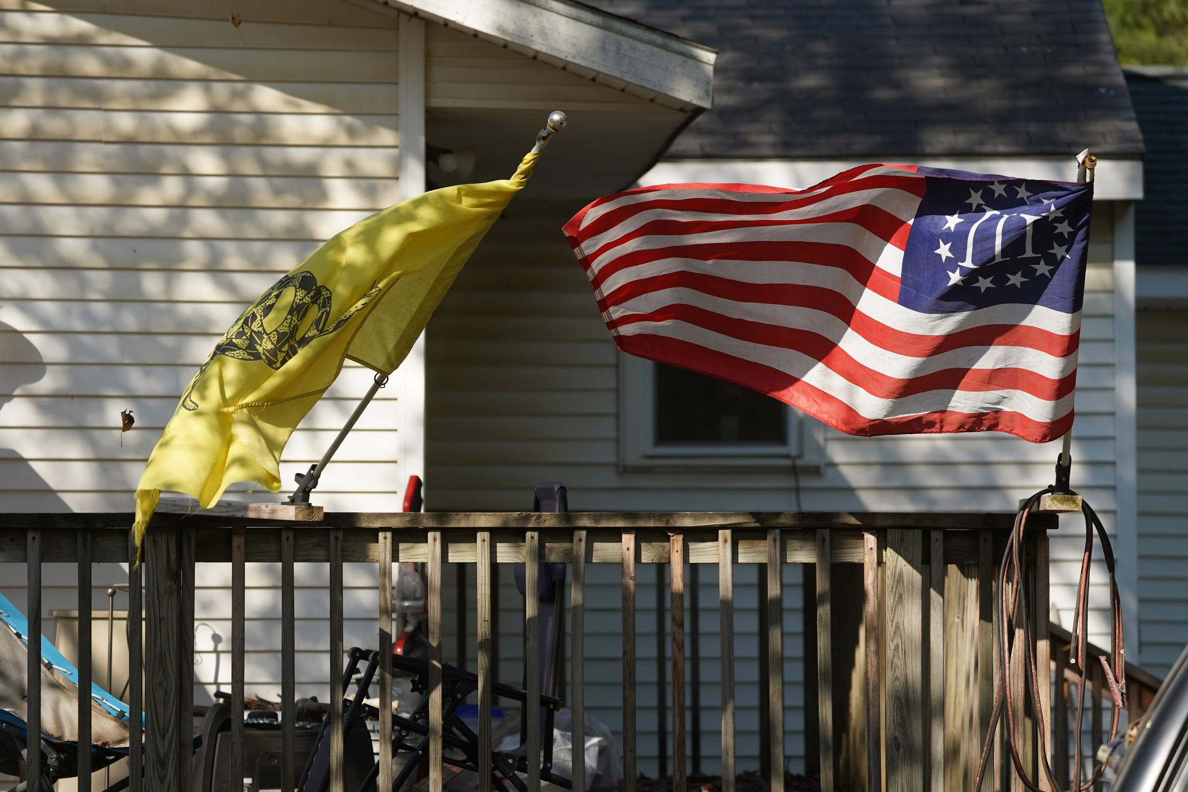 A Three Percenter flag and a Gadsden Flag fly onthe home of Michael Null in Plainwell, Mich., on October 9, 2020. Null one of 13 suspects accused of plotting to abduct and possibly harm Michigan Gov. Gretchen Whitmer. (Ryan Garza—USA Today Network/Sipa USA)