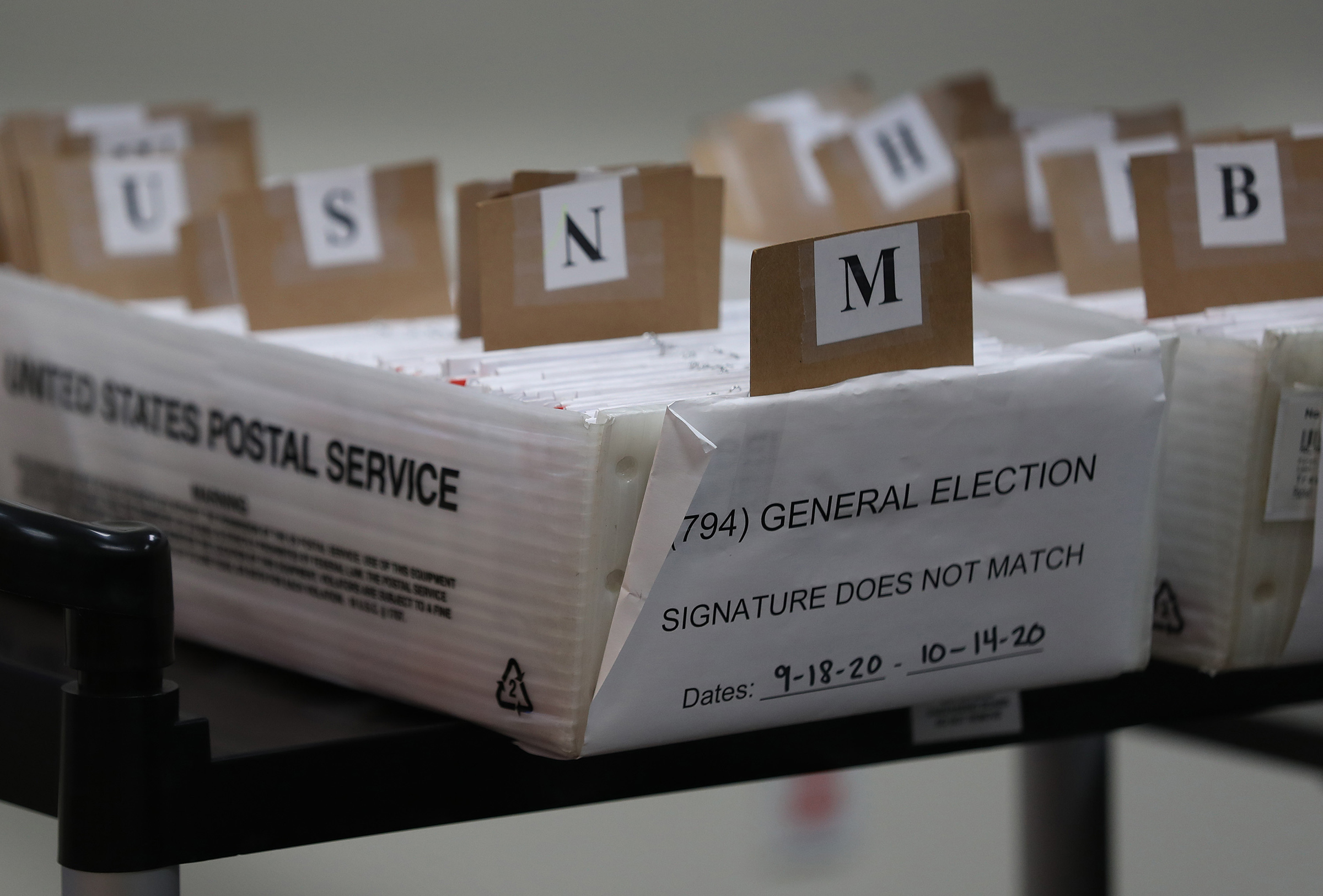 Boxes for Vote-by-Mail ballots that need to be reviewed due to signature discrepancies are seen ahead of the Nov. 3 general election at the Miami-Dade County Elections Department on Oct. 15 in Doral, Fla. (Joe Raedle—Getty Images)