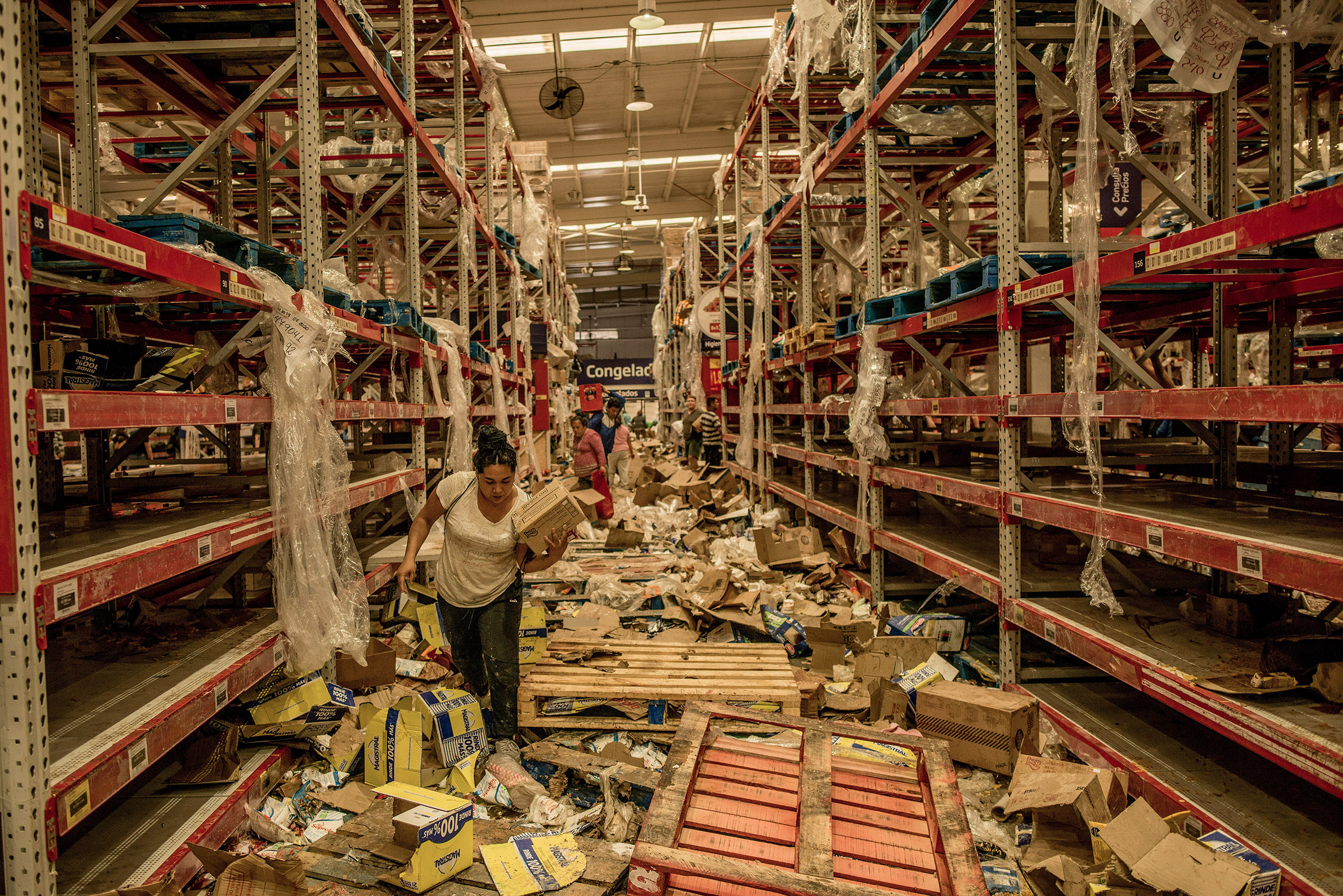 People look through the remains of a looted supermarket in Santiago, Chile, on Oct. 23, 2019. (Tomas Munita—The New York Times/Redux)