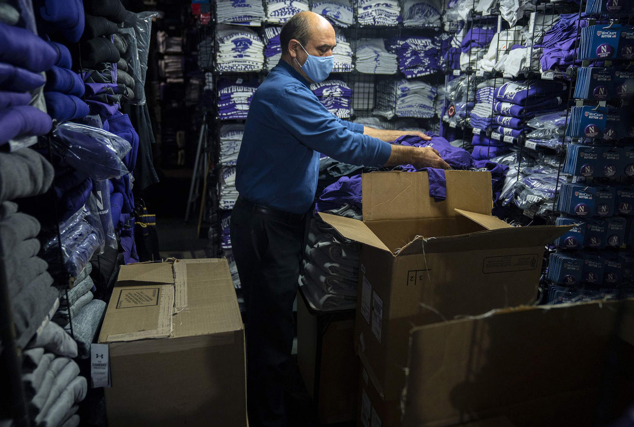 David Haghnaji, owner of Campus Gear in downtown Evanston, Ill., stocks another of his locations—The Locker Room, across from Ryan Field—with new Northwestern gear on Oct. 15, 2020. (E. Jason Wambsgans—Chicago Tribune/TNS/Sipa USA)