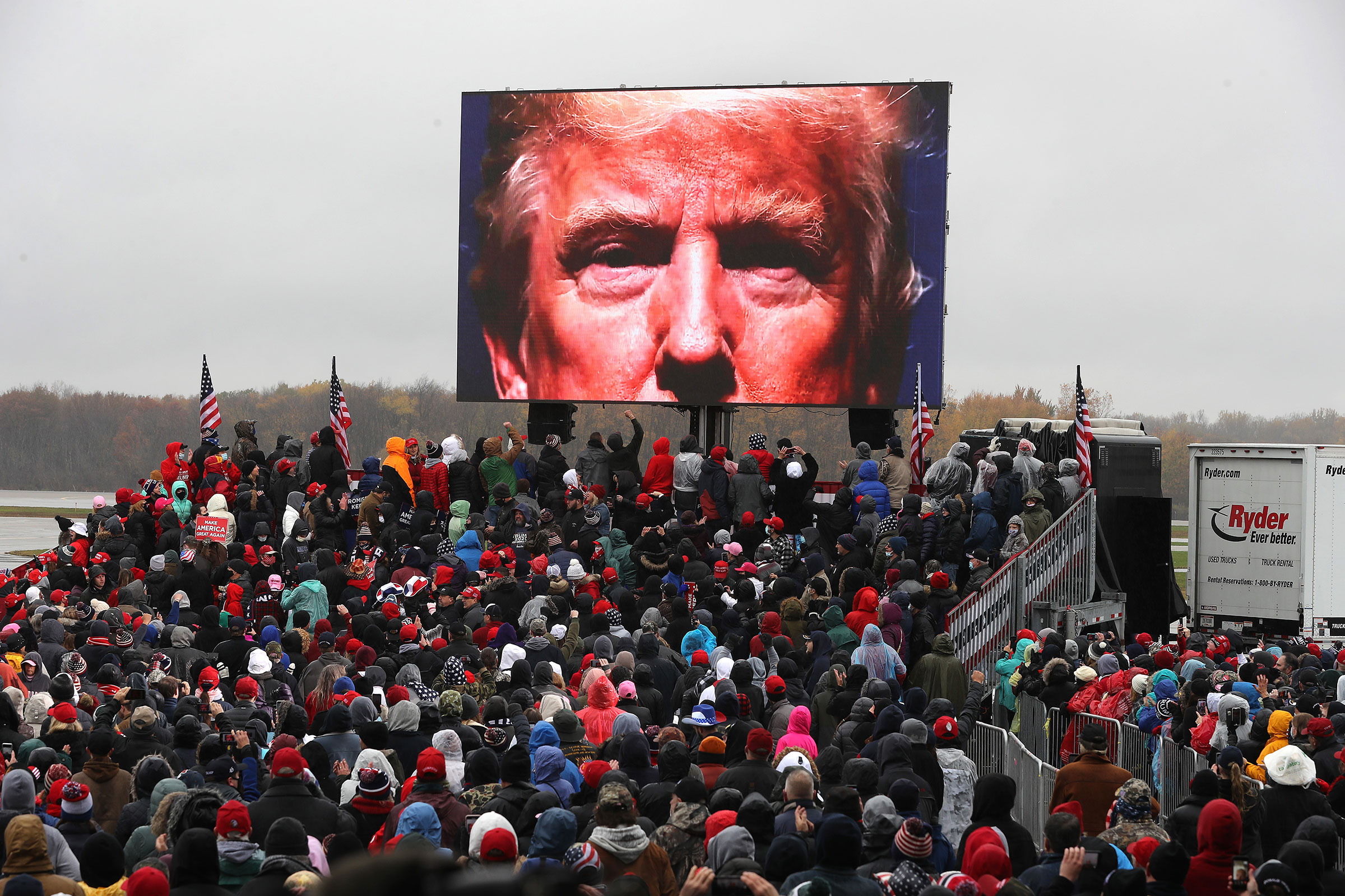 Supporters watch a video of President Donald Trump while waiting for his arrival at a campaign rally at Capital Region International Airport in Lansing, Mich. on Oct. 27, 2020. (Chip Somodevilla—Getty Images)