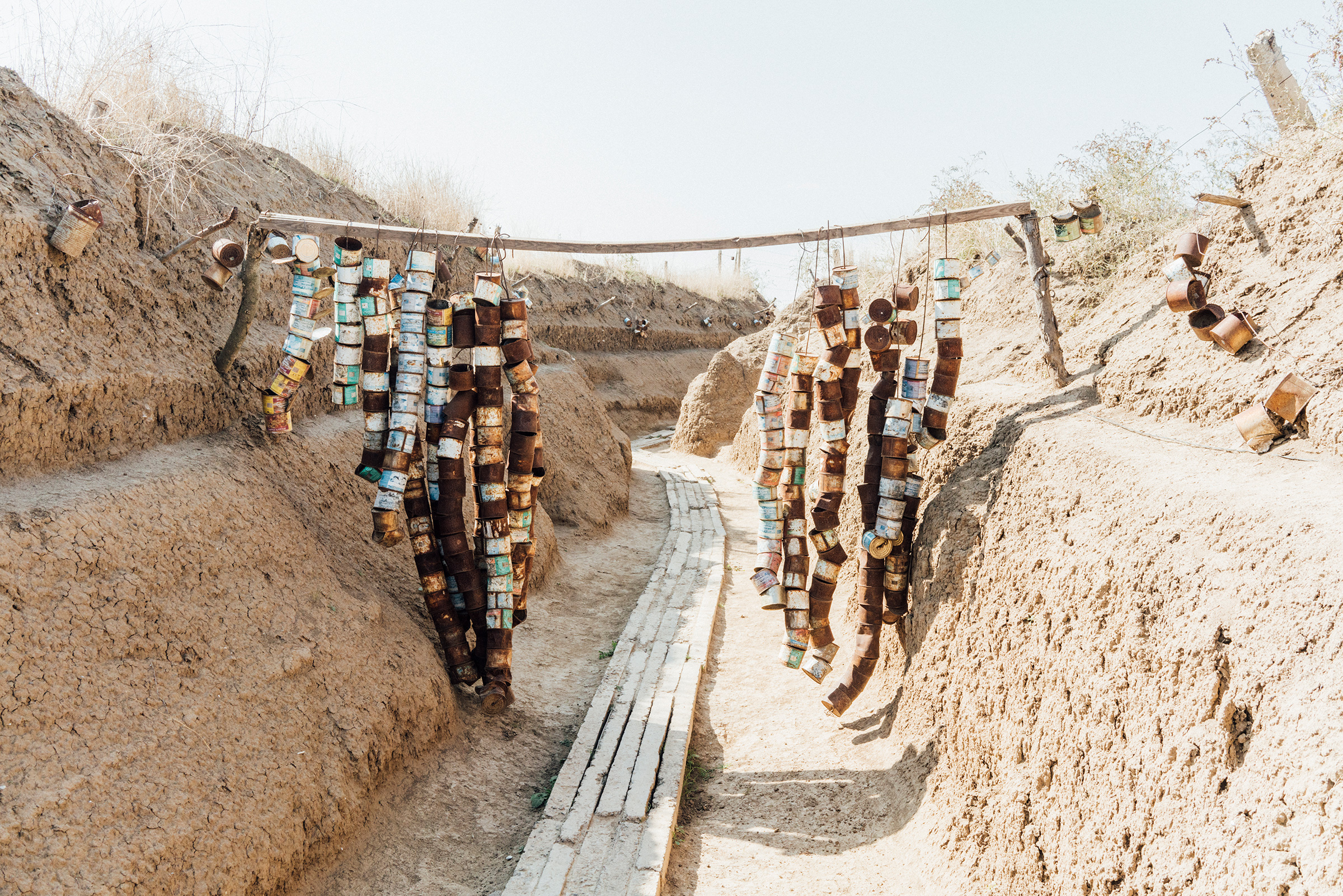 Strings of empty ration cans hang in a frontline trench near the town of Askeran.