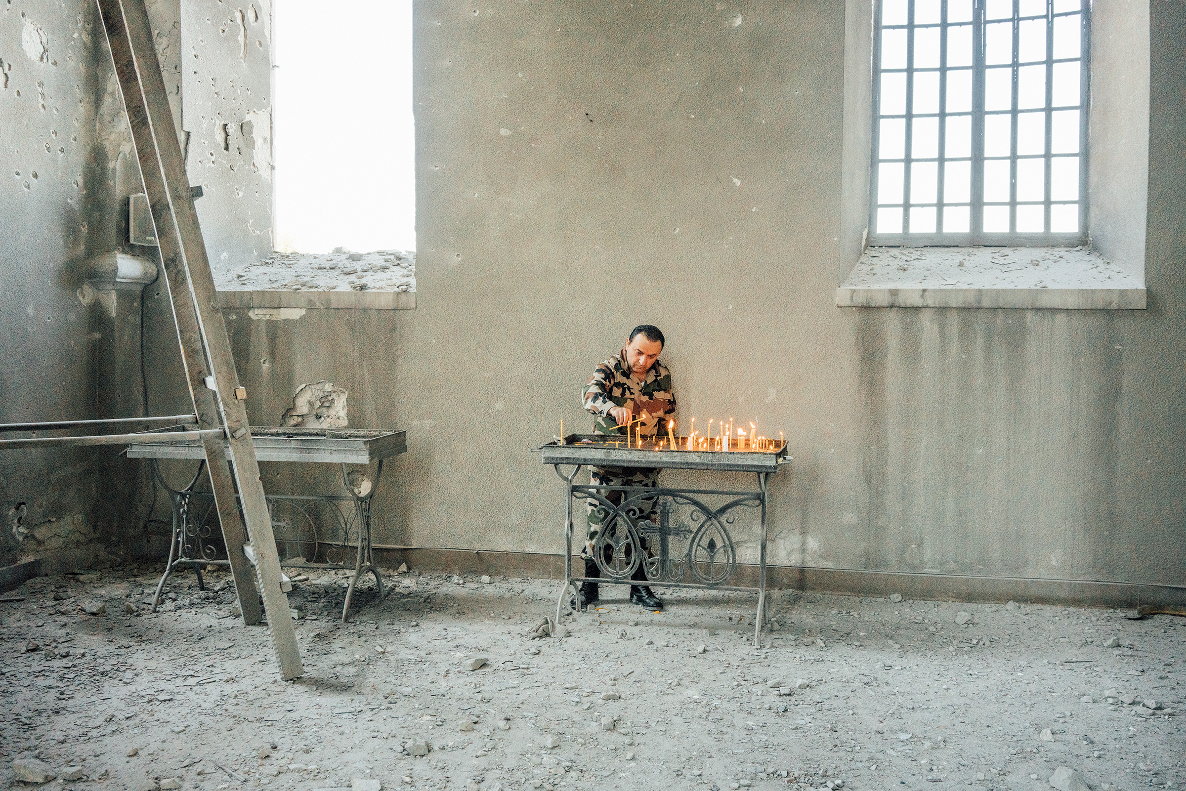 An Armenian soldier lights candles inside the Holy Savior Cathedral, which was damaged by shelling, in the town of Shusha outside Stepanakert.