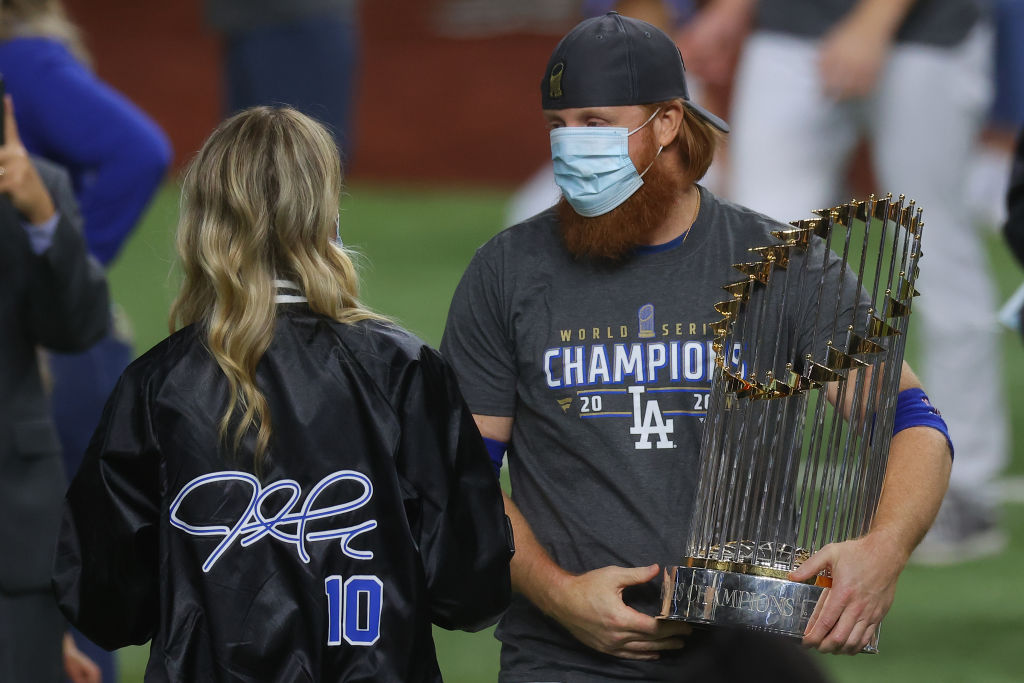 Justin Turner #10 of the Los Angeles Dodgers and his wife Kourtney Pogue, hold the Commissioners Trophy after the teams 3-1 victory against the Tampa Bay Rays in Game Six to win the 2020 MLB World Series at Globe Life Field on October 27, 2020 in Arlington, Texas. (Ronald Martinez—Getty Images)