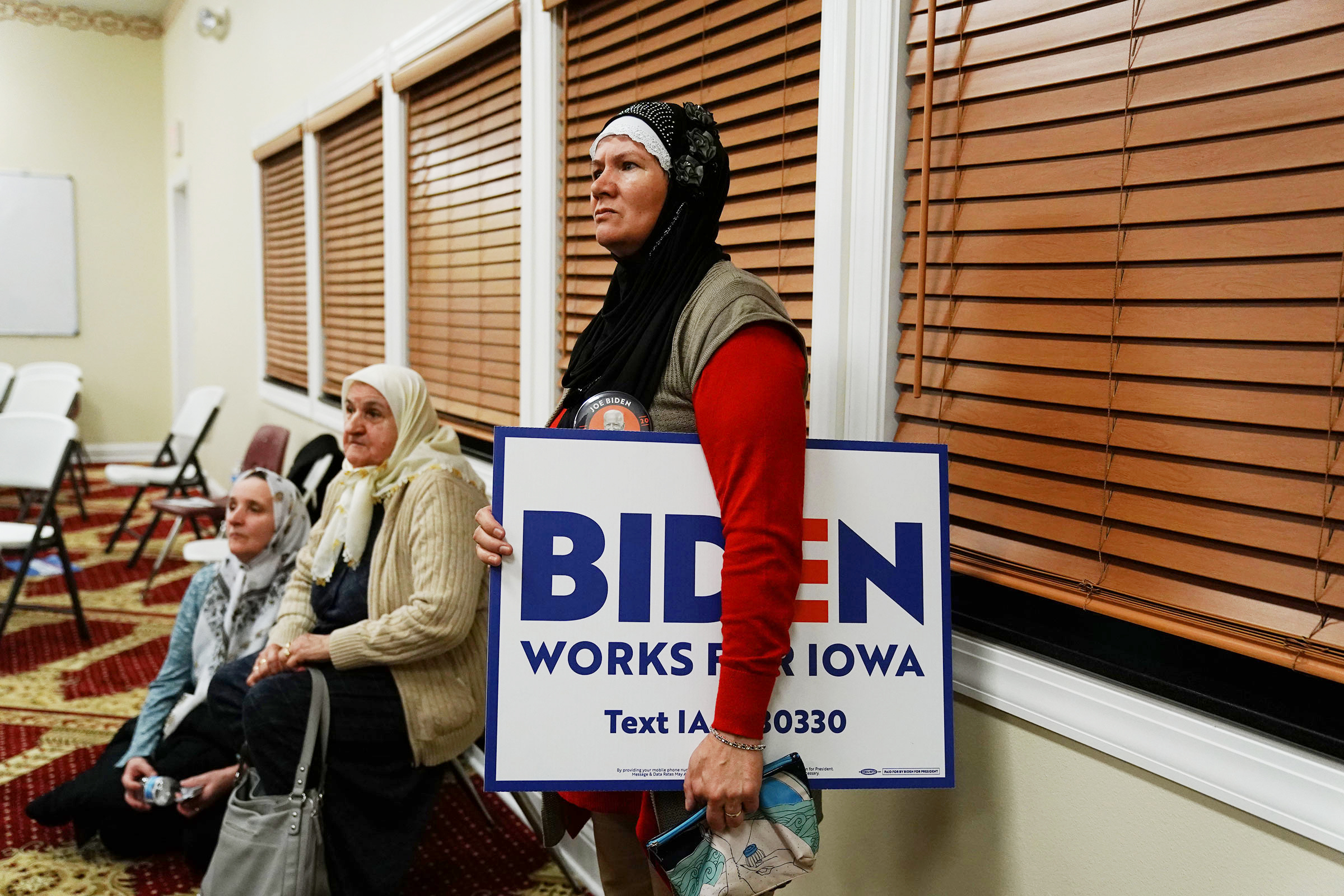 A participant holds a campaign sign for Biden during the first-in-the-nation Iowa caucus in Des Moines.