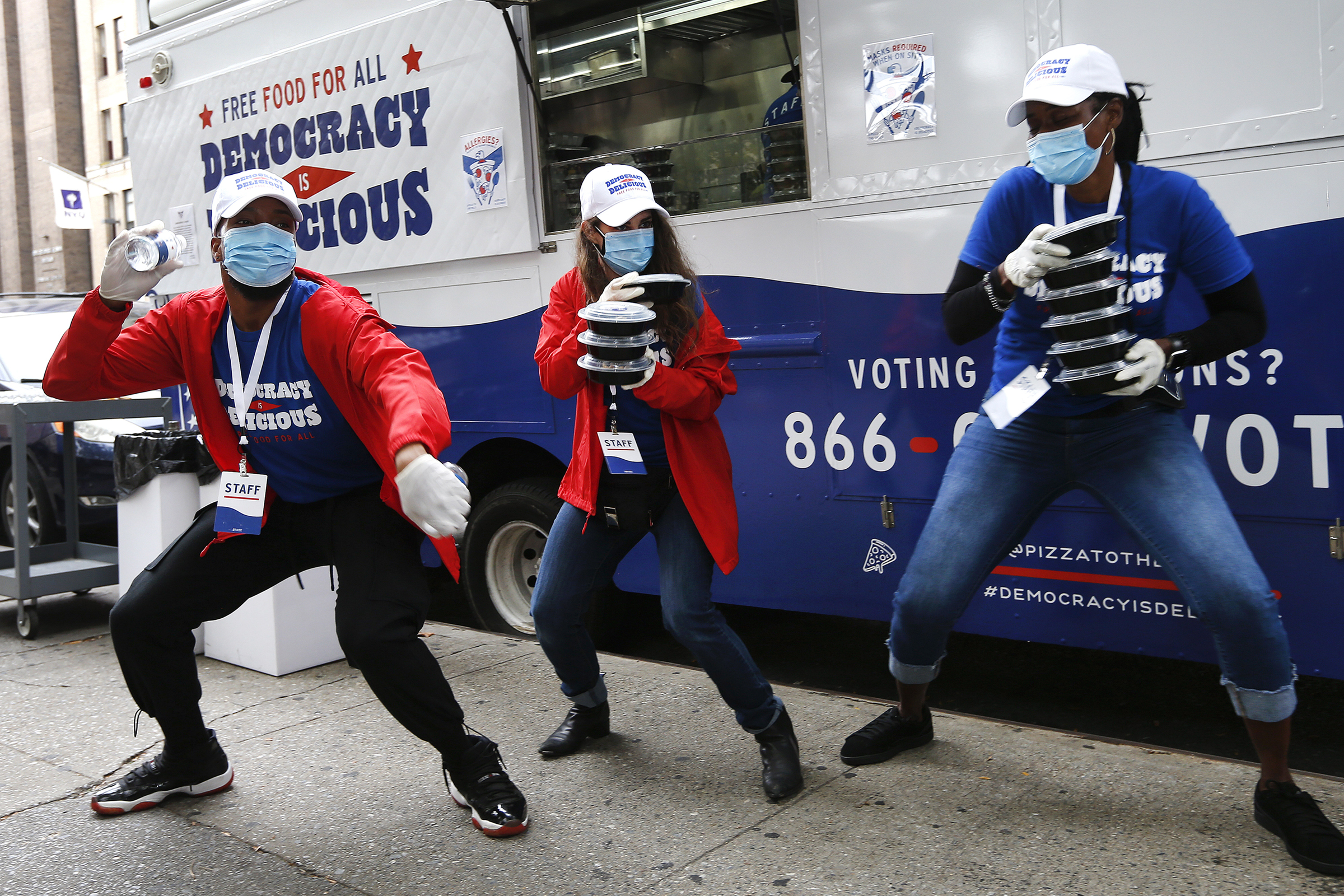 Pizza to the Polls food truck staff dance and spread good energy to voters waiting in line on early voting day in New York, on Oct. 24, 2020. (Jason DeCrow—AP/Pizza to the Polls)