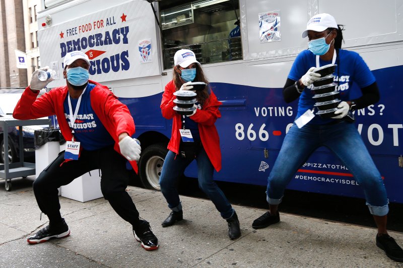 Pizza to the Polls food truck staff dance and spread good energy to voters waiting in line on early voting day in New York, on Oct. 24, 2020.