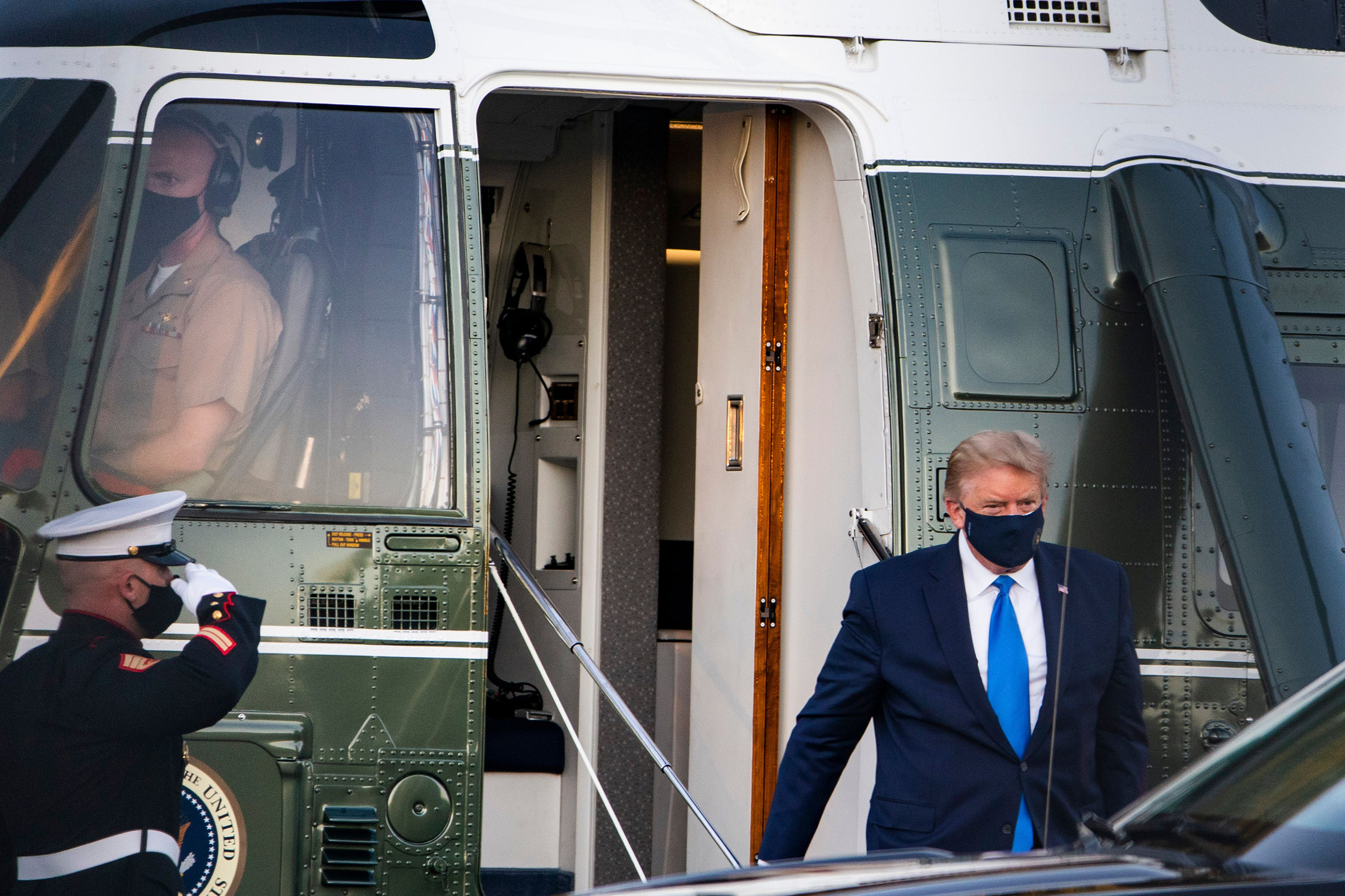 President Trump walks off Marine One after landing at Walter Reed National Military Medical Center in Bethesda, Md., on Oct. 2, 2020. His positive COVID-19 test comes after months of playing down the severity of the pandemic that has killed 207,000 Americans.