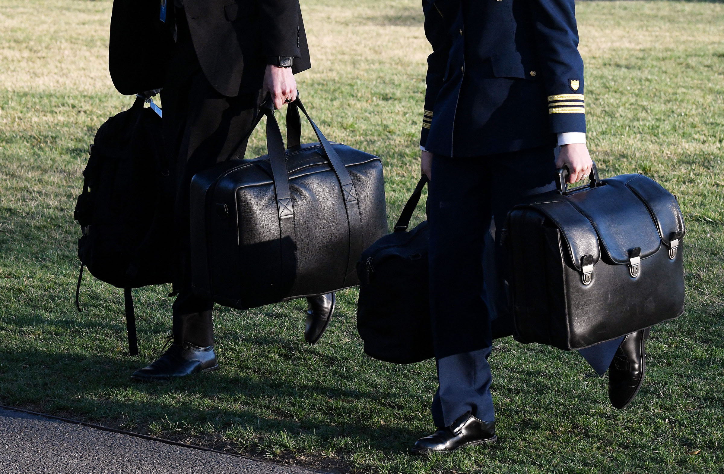 A military aide carries the nuclear football across the South Lawn at the White House in Washington, DC, on March 3, 2018. (Olivier Douliery—Abaca Press/Reuters)