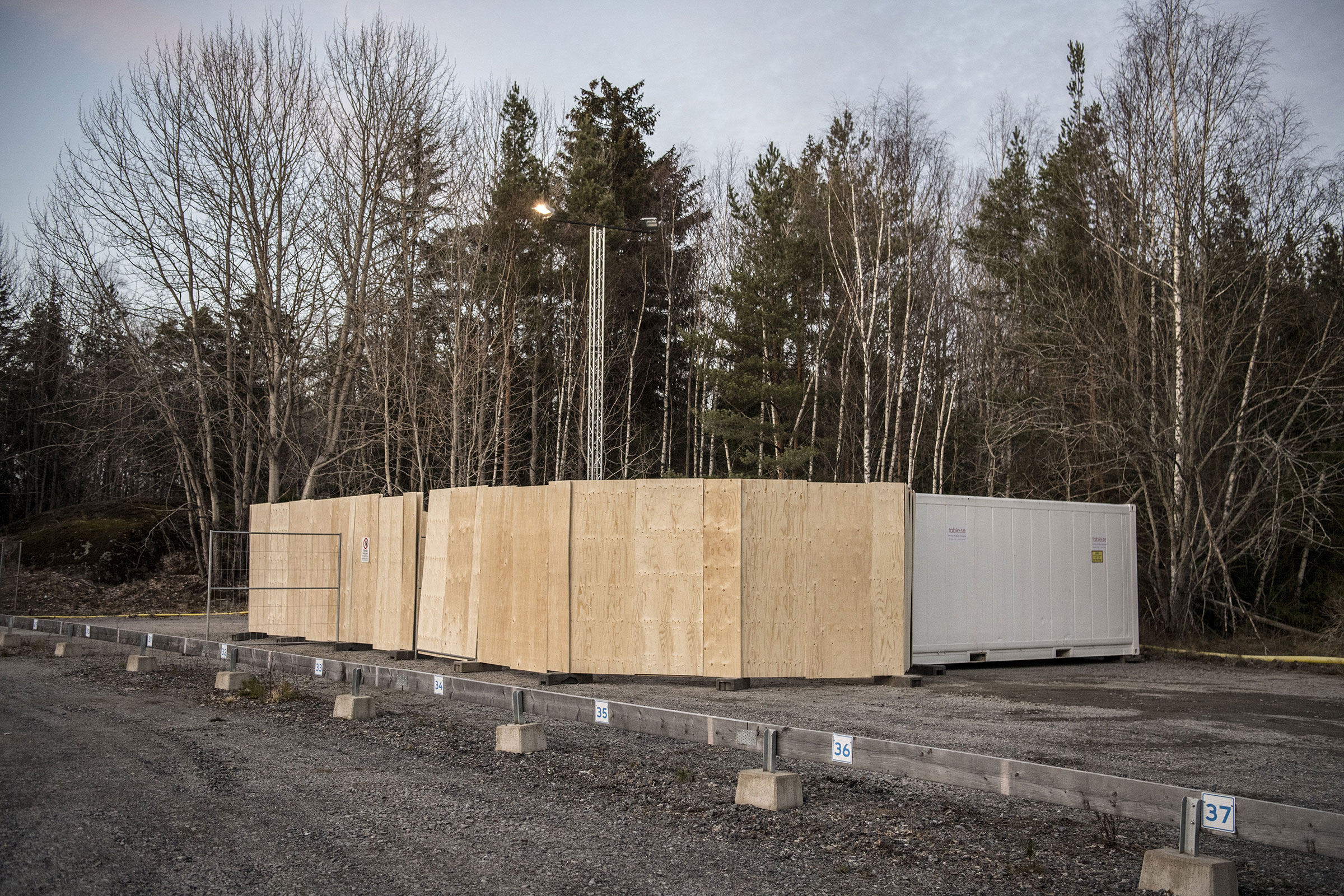 Refrigeration containers to be used on standby as makeshift morgues to store people who have died from COVID-19 set up behind Karolinska University Hospital in Huddinge, Sweden on March 26, 2020. (IBL/Shutterstock)