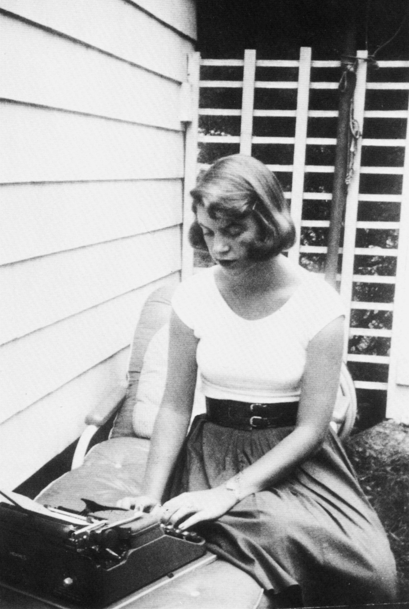 Plath typing in the backyard, Wellesley, Massachusetts, 1954