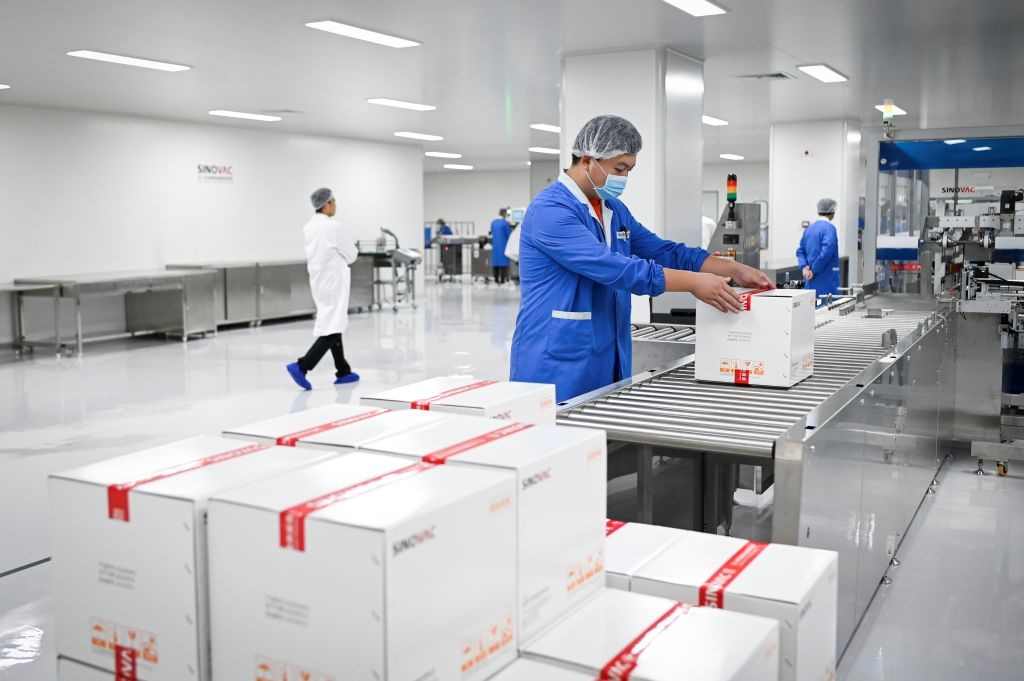 A staff member works during a media tour of a new factory built to produce a COVID-19 coronavirus vaccine at Sinovac, one of 11 Chinese companies approved to carry out clinical trials of potential coronavirus vaccines, in Beijing on September 24, 2020. (Wang Zhao–AFP/Getty Images)