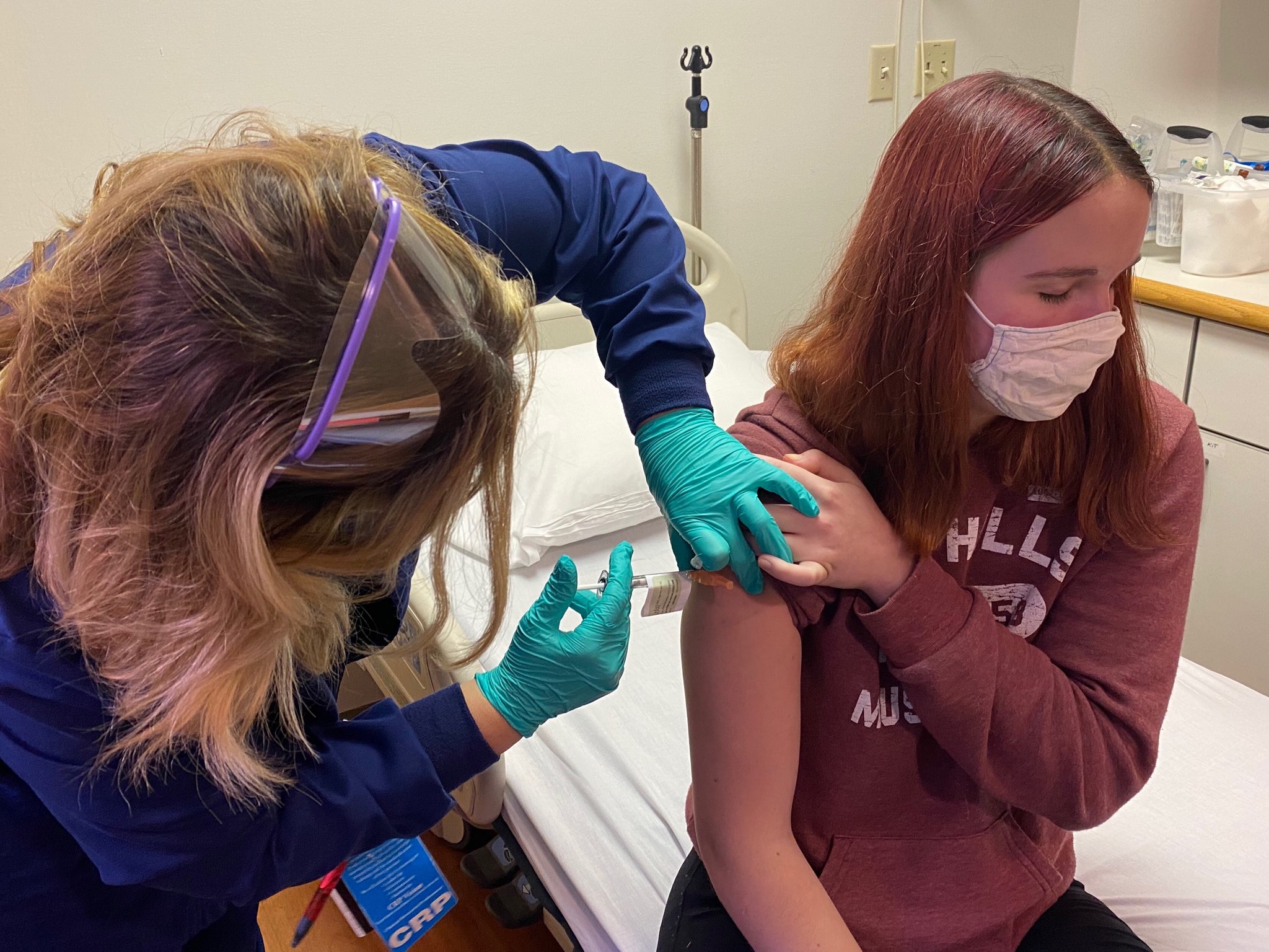 Clinical research coordinator Tammy Lewis-McCauley administers Katelyn Evans, 16, an injection as part of the hospital’s clinical trial of the Pfizer COVID-19 vaccine. (Cincinnati Children's Hospital)