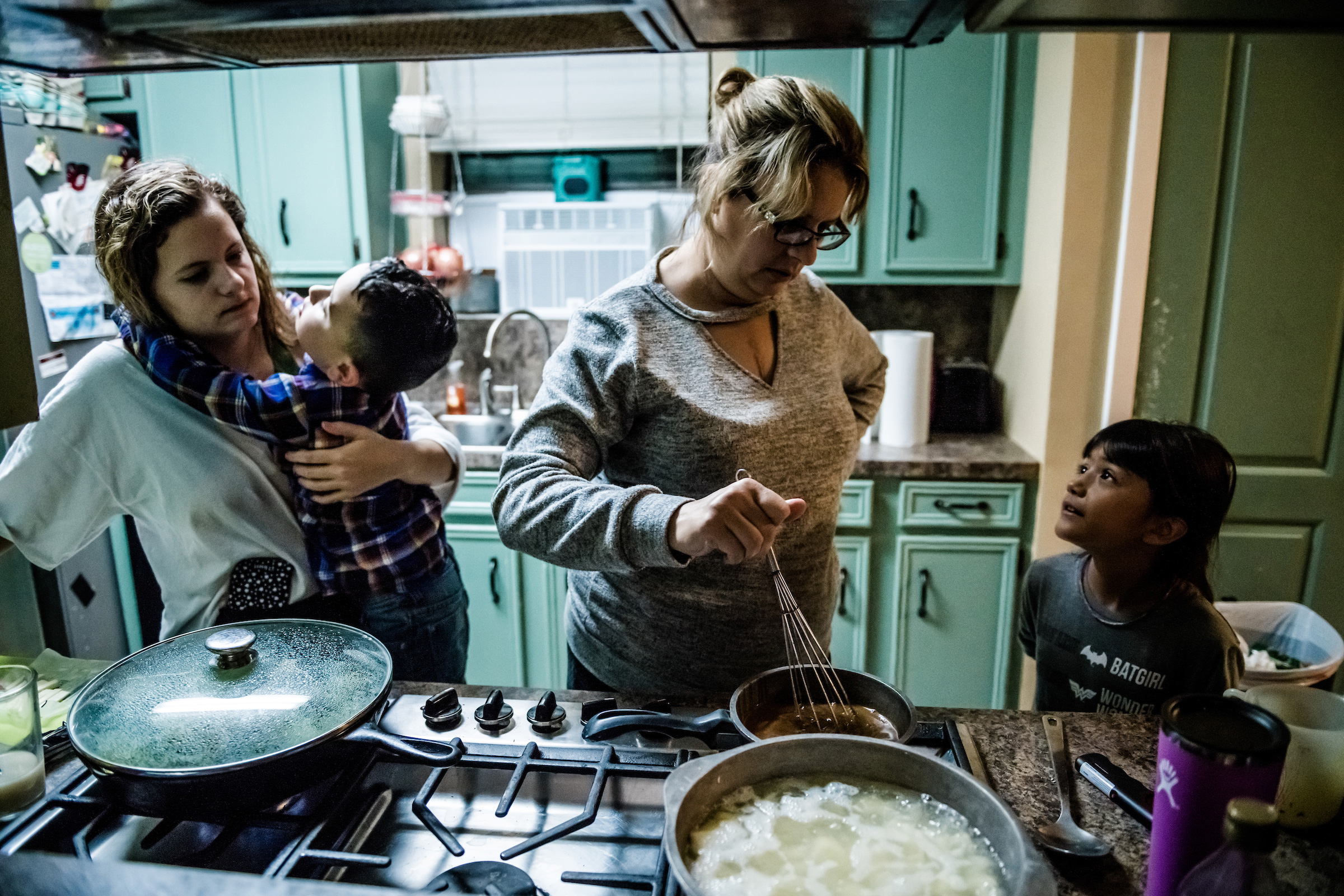 Jessica Higginbotham, second from right, is thankful she was able to cook dinner for her five children on Nov. 17, 2020. She survived heart and kidney transplants in 2019; she and three other members of her family had COVID-19 this year. The health issues, paired with her husband Jeremiah’s losing hours at work, cost the Baytown, Texas, family most of their life savings. (Meridith Kohut for TIME)