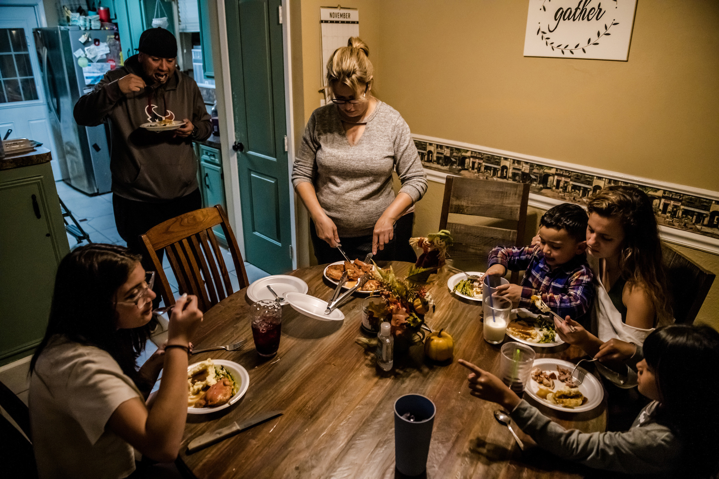 Jessica Higginbotham, center, prepares dinner with her children and husband on Nov. 17. “When it got really bad with the money," says Higginbotham, 40, "it was either pay the light bill or have food on the table." (Meridith Kohut for TIME)