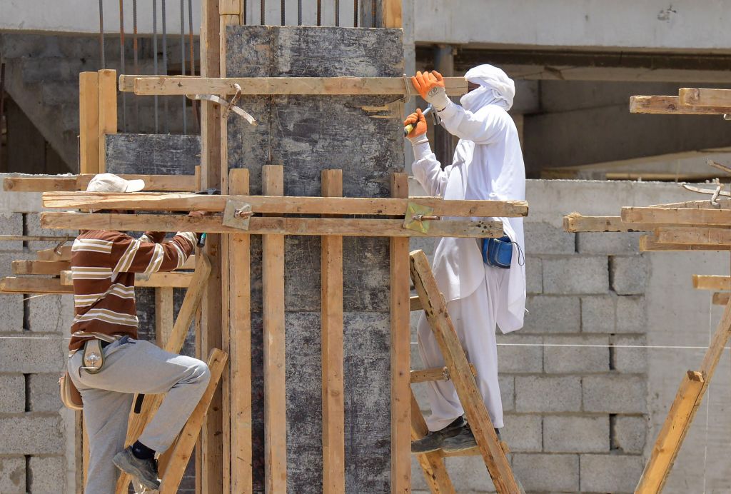 El 6 de junio de 2020, los trabajadores estarán trabajando en un sitio de construcción en la capital saudí, Riad.