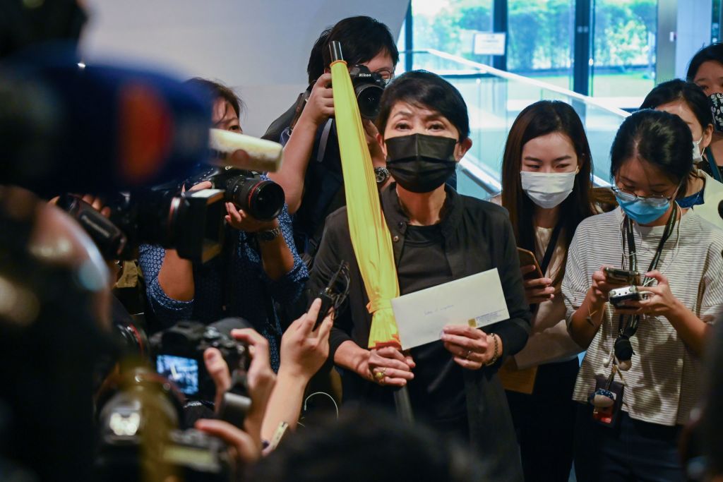 Pro-democracy lawmaker Claudia Mo holds a yellow umbrella and her resignation letter at the Legislative Council in Hong Kong on November 12, 2020, after the pro-democracy bloc said they would resign en masse in protest at the ousting of four of their colleagues by the city's pro-Beijing authorities. (Photo by PETER PARKS/AFP via Getty Images)