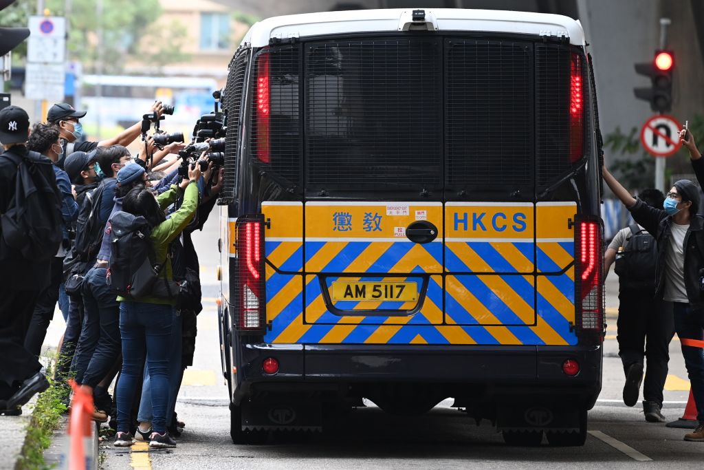 Members of the media surround a correctional services bus purportedly carrying pro-democracy activists Agnes Chow, Ivan Lam and Joshua Wong as it leaves court in Hong Kong on November 23, 2020. (PETER PARKS/AFP via Getty Images)