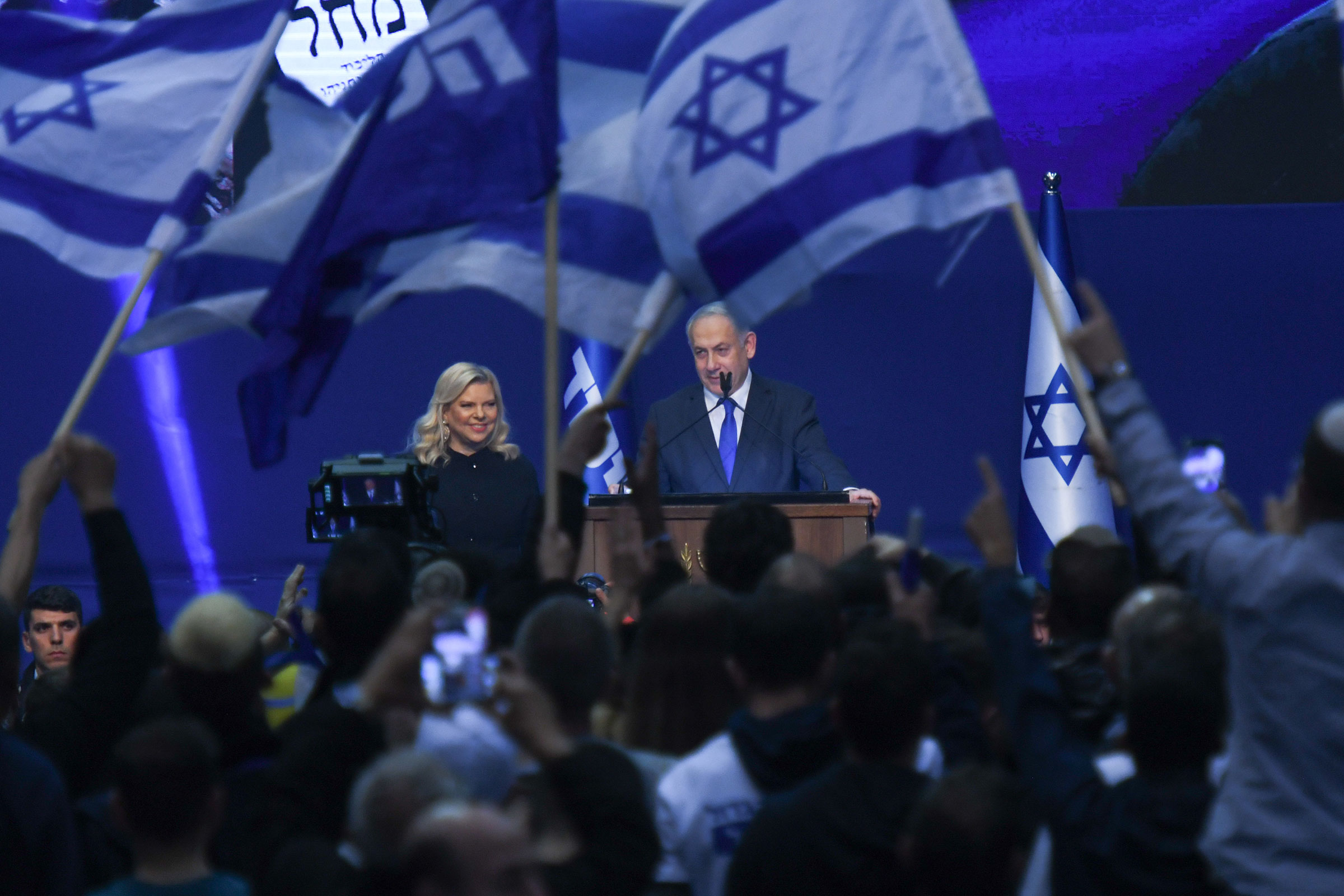 Israeli Prime Minister Benjamin Netanyahu stands next to his wife Sara as he speaks to supporters following the announcement of exit polls in Israel's election at his Likud party headquarters in Tel Aviv. on March 3, 2020.
