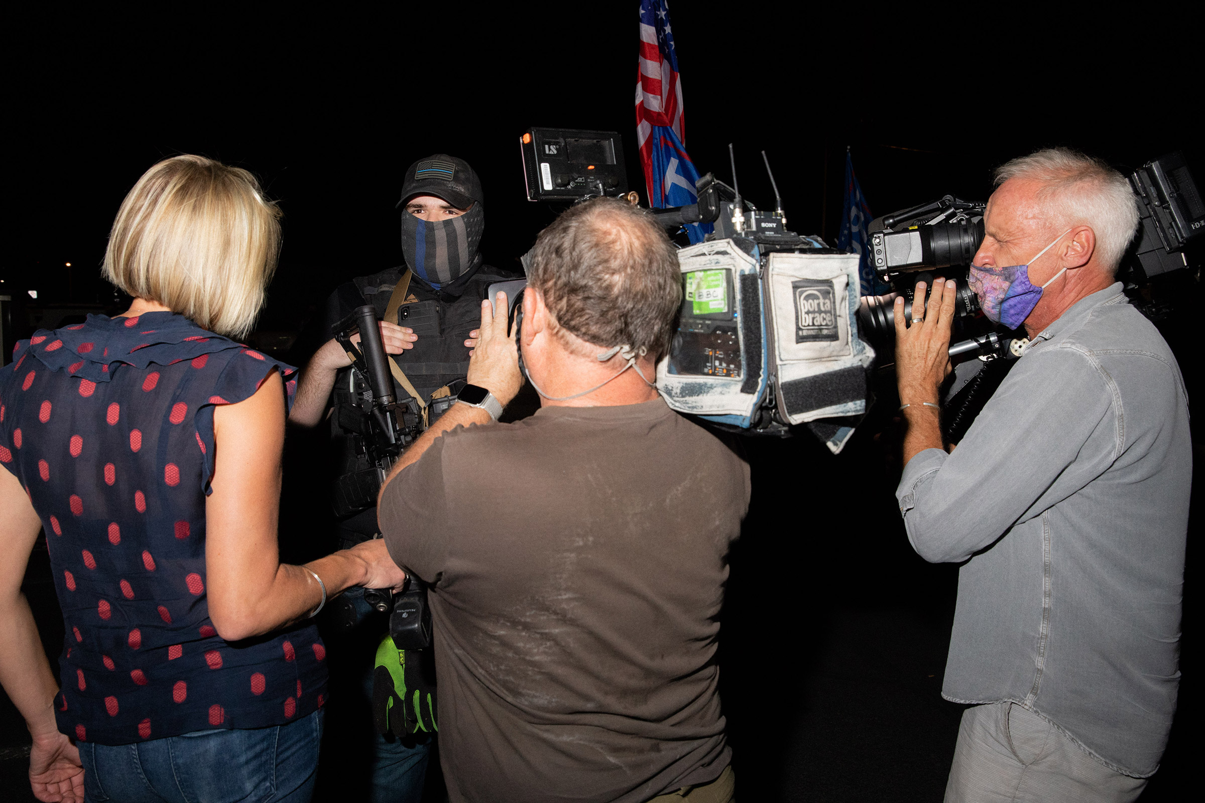 A member of a militia is flanked by cameras at the Maricopa County Elections Office in Phoenix, AZ on November 5, 2020