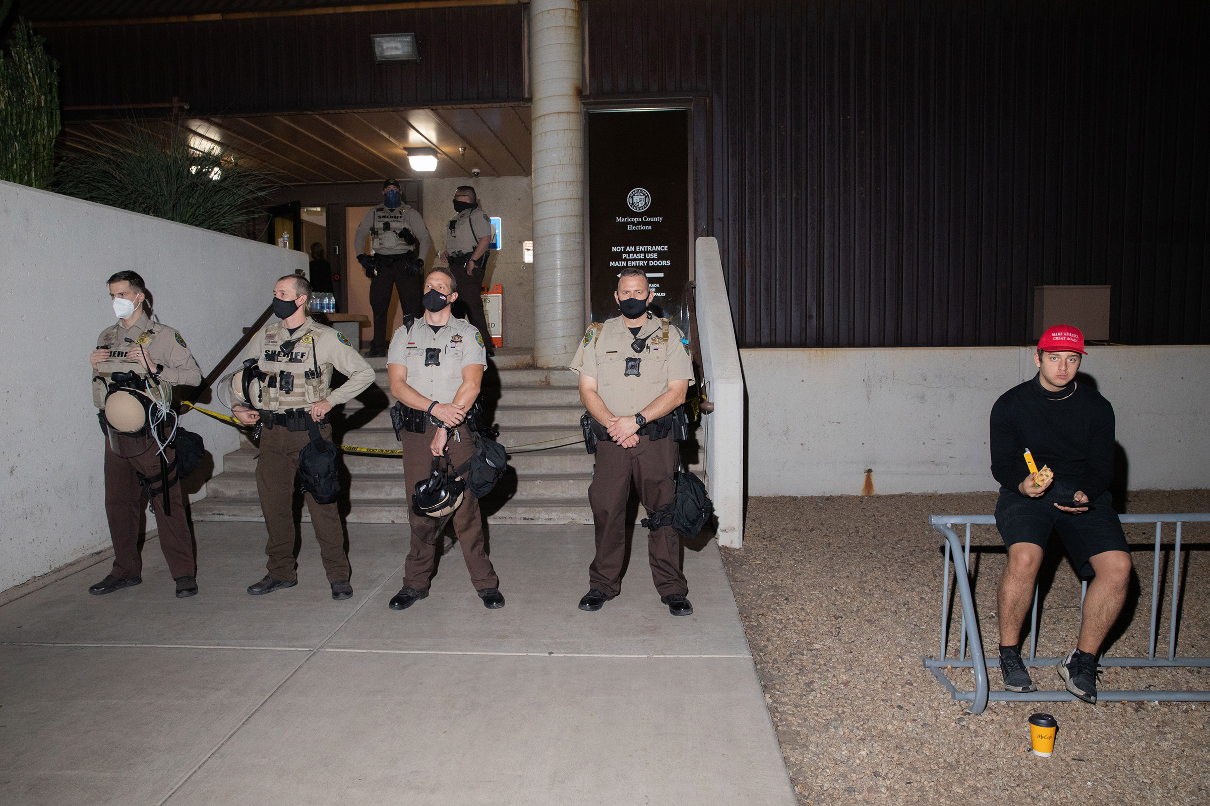 Trump supporter with police at the Mariscopa County Elections Office in Phoenix, AZ on November 4, 2020