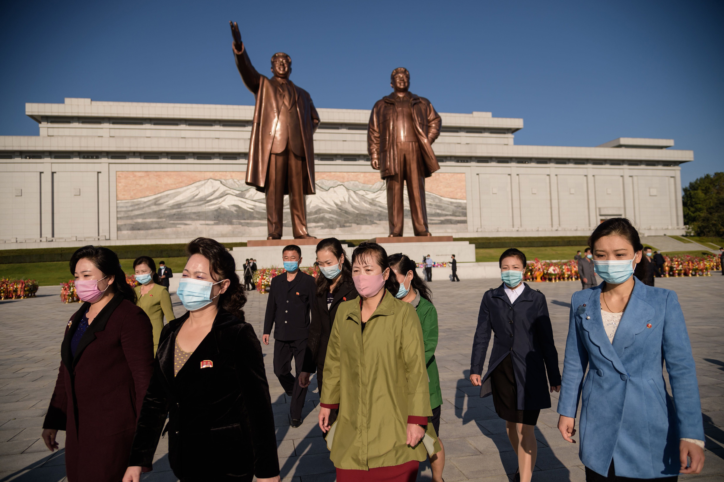 La gente se va después de presentar sus respetos a las estatuas de los difuntos líderes norcoreanos Kim Il Sung y Kim Jong Il en la colina Mansu en Pyongyang el 10 de octubre.
