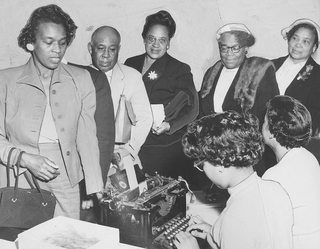 Black men and women registering to vote in 1958