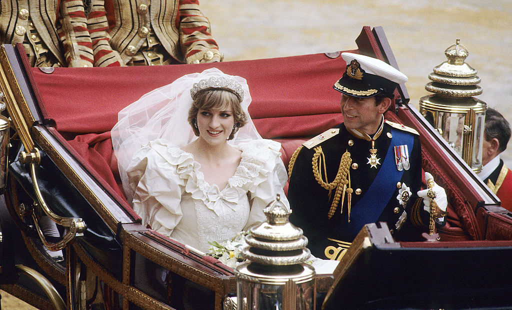 Prince Charles, Prince of Wales and Diana, Princess of Wales, wearing a wedding dress designed by David and Elizabeth Emanuel and the Spencer family Tiara, ride in an open carriage, from St. Paul's Cathedral to Buckingham Palace, following their wedding on July 29, 1981 in London, England. (Anwar Hussein—WireImage via Getty Images)