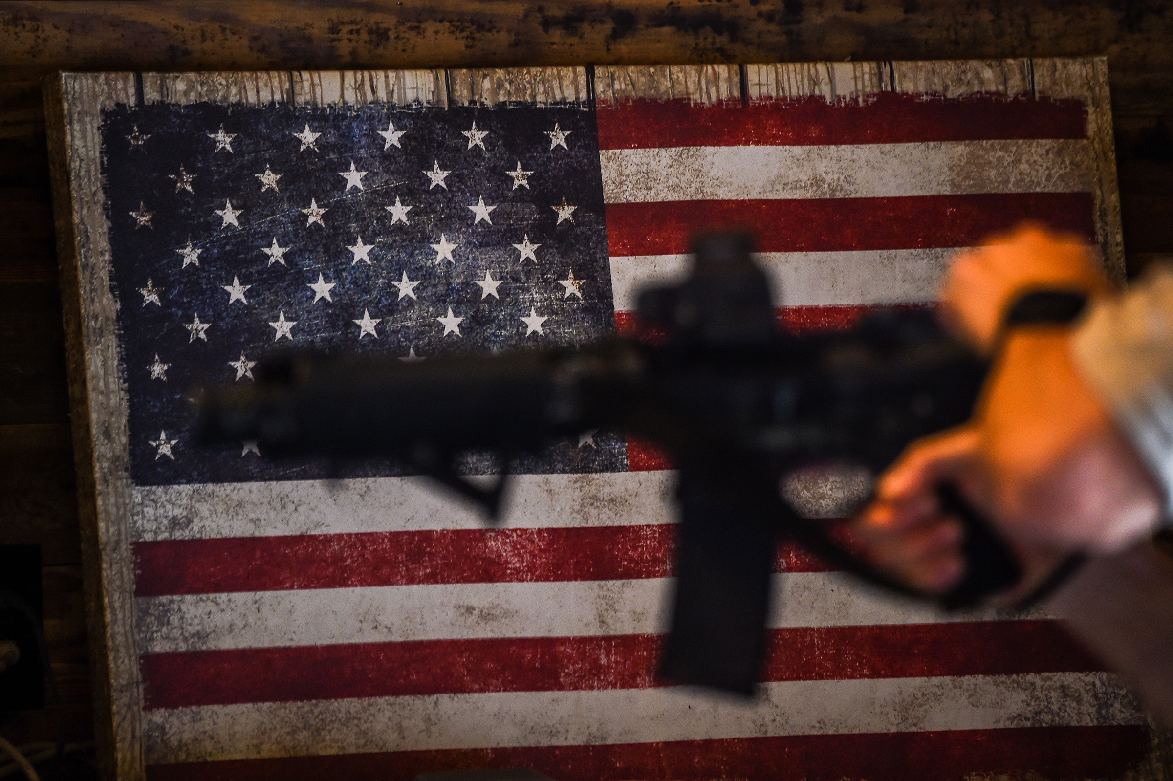 An instructor teaches handling of AR-15 semi-automatic rifles with a US flag in the background during a shooting course at Boondocks Firearms Academy in Jackson, Miss. on Sept. 26 (Chandan Khanna—AFP/Getty Images)