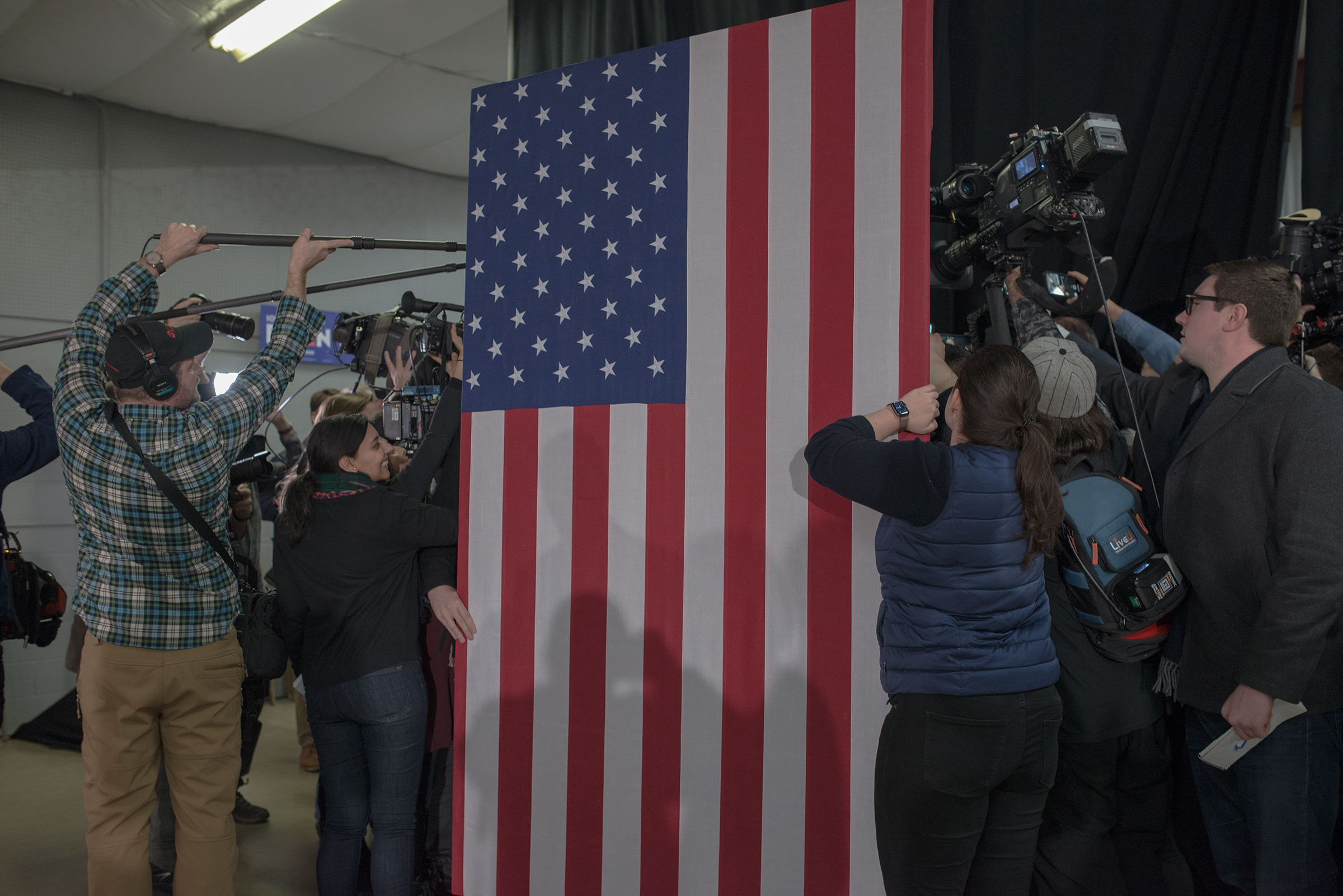 Journalists swarm Joe Biden behind an American flag in Mason City, Iowa, on Jan. 22, 2020. (September Dawn Bottoms for TIME)