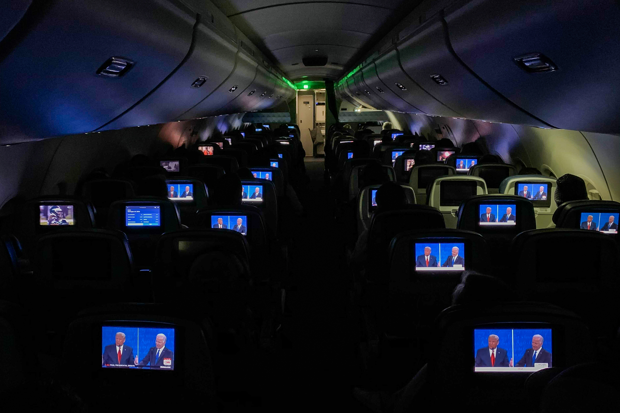 The final presidential debate between President Trump and Joe Biden appears on television screens during a flight from Detroit on Oct. 22, 2020.