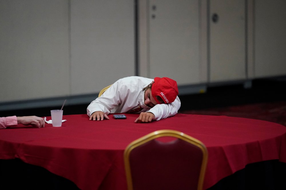 Reflecting the exhaustion on both sides of the aisle, a Trump fan rests on a table at an election-night party in Las Vegas.