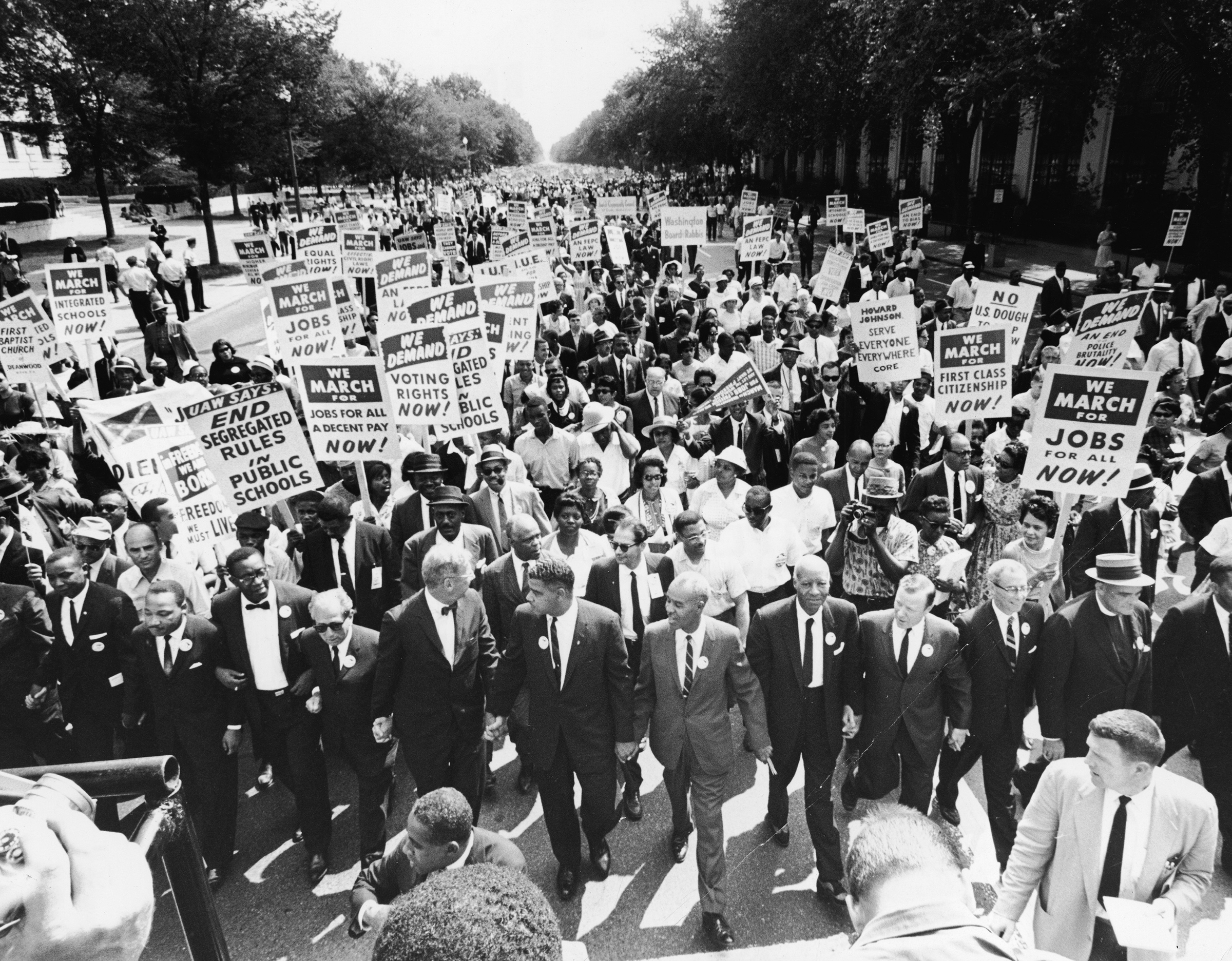 Civil rights leaders including James Meredith, Martin Luther King, Jr., Roy Wilkins, A. Phillip Randolph, and Walther Reuther, hold hands as they lead a crowd at the March on Washington in Washington D.C., Aug. 28, 1963