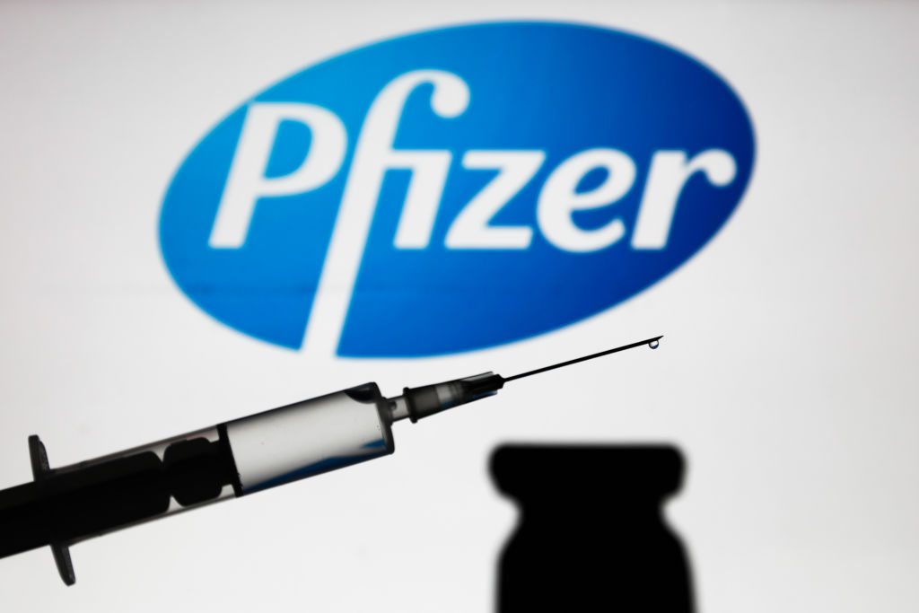 Medical syringe is seen with Pfizer company logo displayed on a screen in the background in this illustration photo taken in Poland on Nov. 16, 2020. (Jakub Porzycki–NurPhoto/Getty Images)