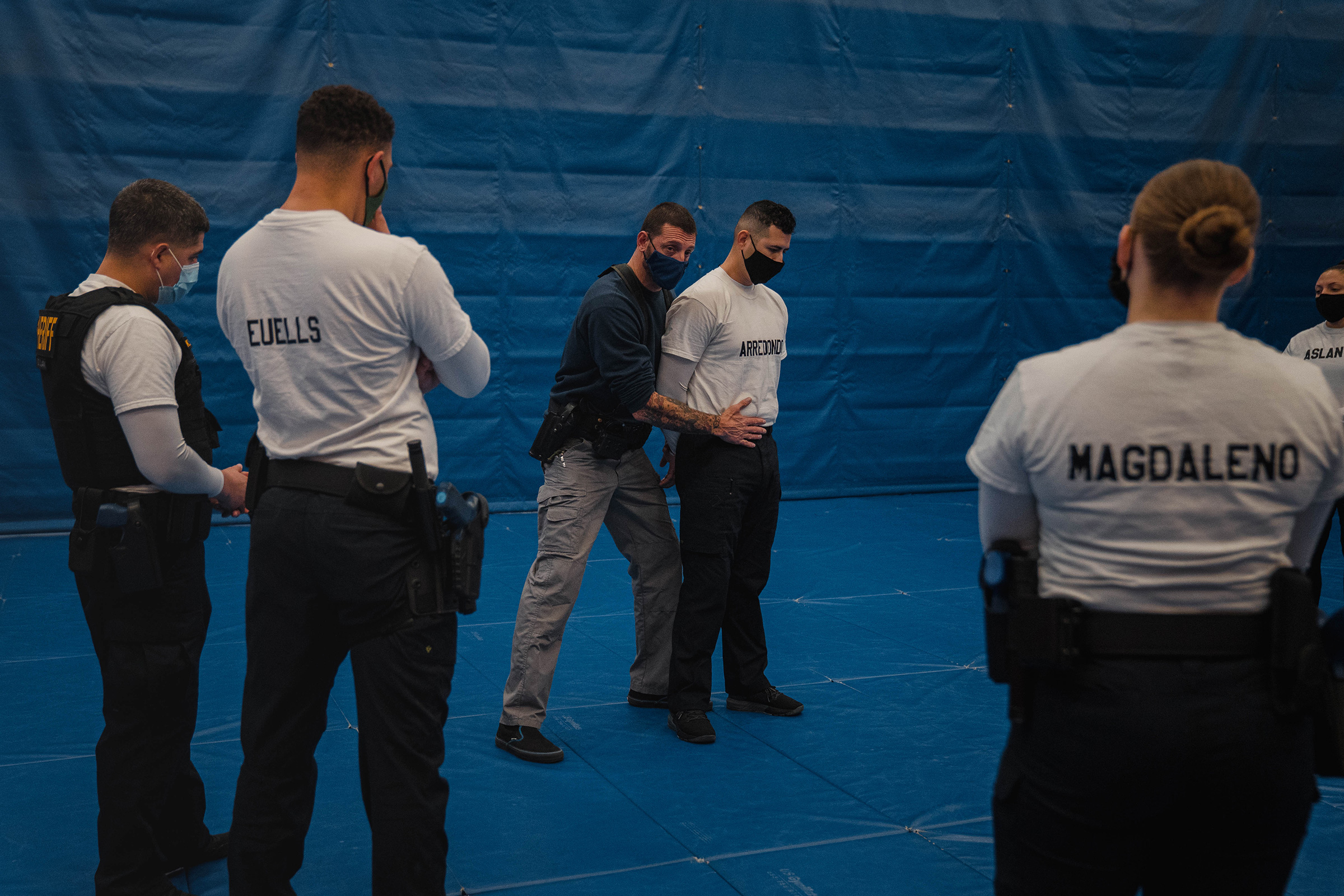 Instructor Javier Sola teaches frisking and handcuffing methods to police recruits.