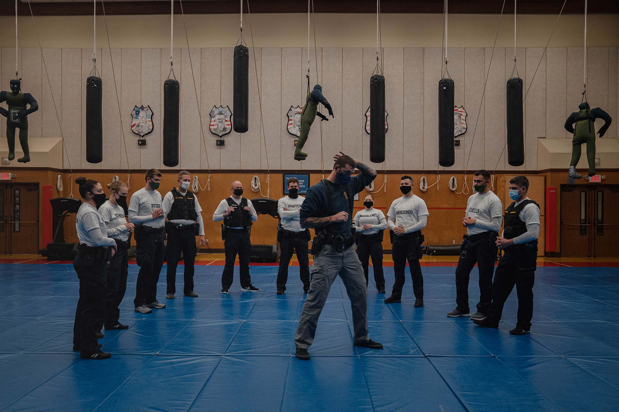 With punching bags and dummies overhead, instructor Javier Sola teaches frisking and handcuffing techniques to recruits at the Washington State Criminal Justice Training Commission facility in Burien, Wash., on Oct. 22. Washington State is one of the few places in the U.S. that requires all recruits to go through the state-run Basic Law Enforcement Academy, except for those becoming state patrol officers, a system that advocates of police reform support. (Jovelle Tamayo for TIME)