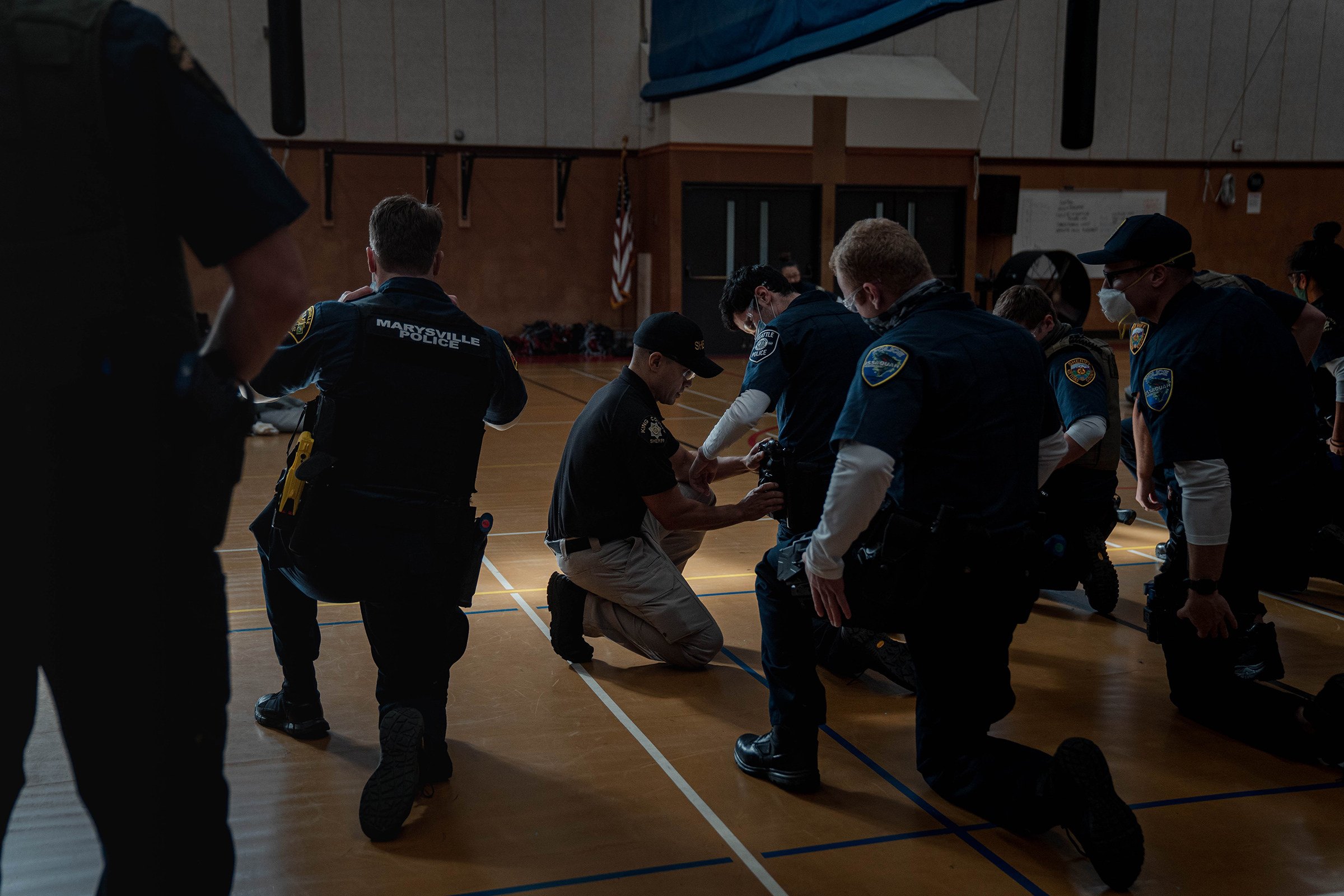 Police recruits practice holstering a taser at an introductory taser class.