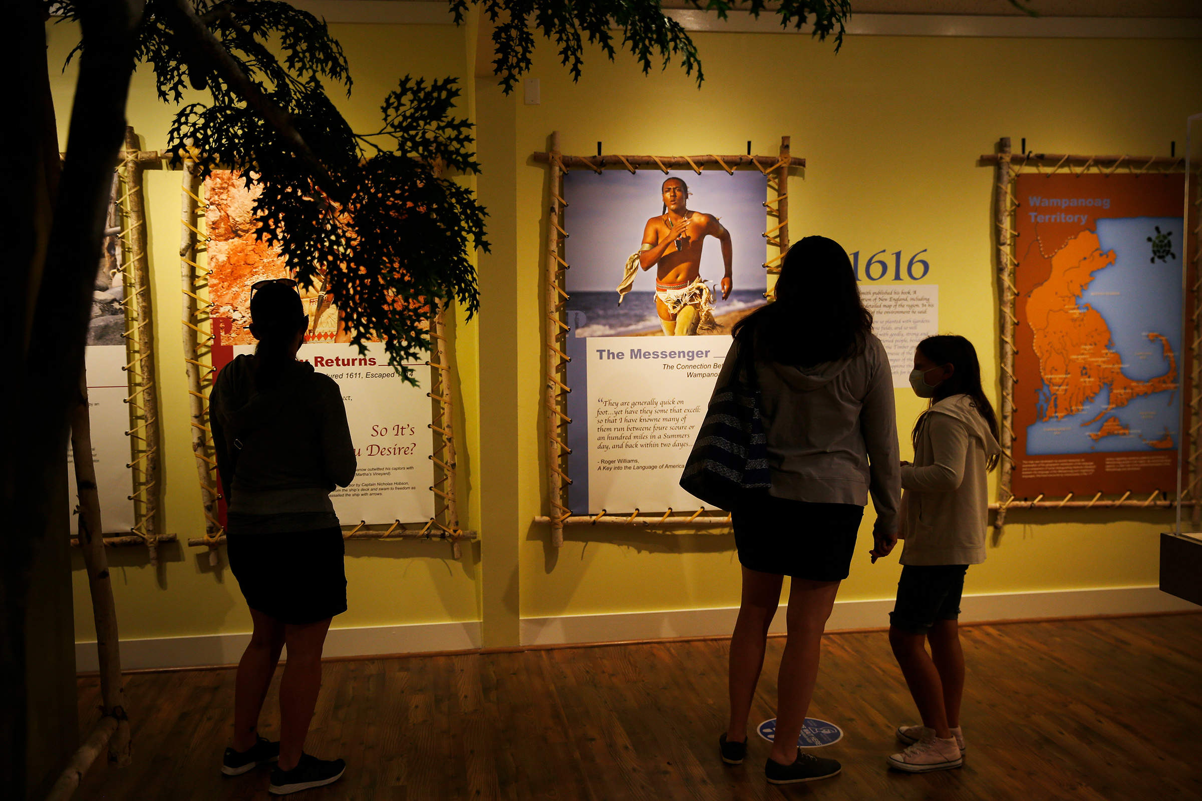 Visitors to the Pilgrim Monument and Provincetown Museum pause to examine a new exhibit about early interactions between the Pilgrims and the Wampanoag tribe in Provincetown, MA on Aug. 27