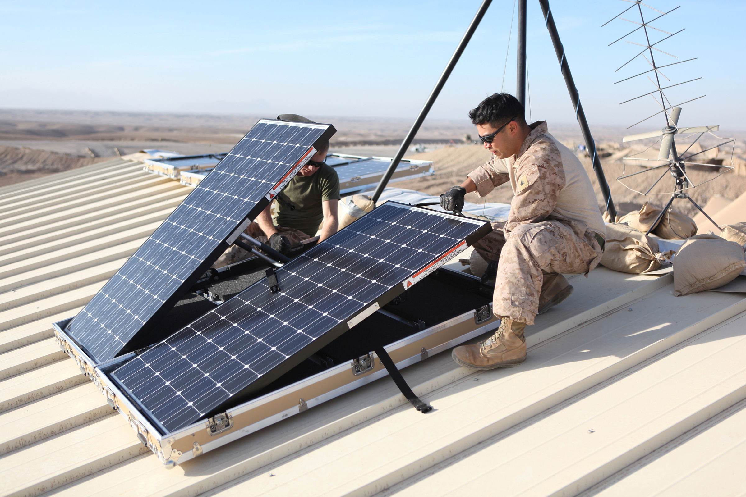U.S. Marine Corps Corporal Robert G. Sutton (L) and Corporal Moses E. Perez install new solar panels on Combat Outpost Shukvani, Helmand province, Afghanistan, on Nov. 19, 2012 (U.S. Marine Corps/Lance Cpl. Alexander Quiles/Handout/REUTERS)