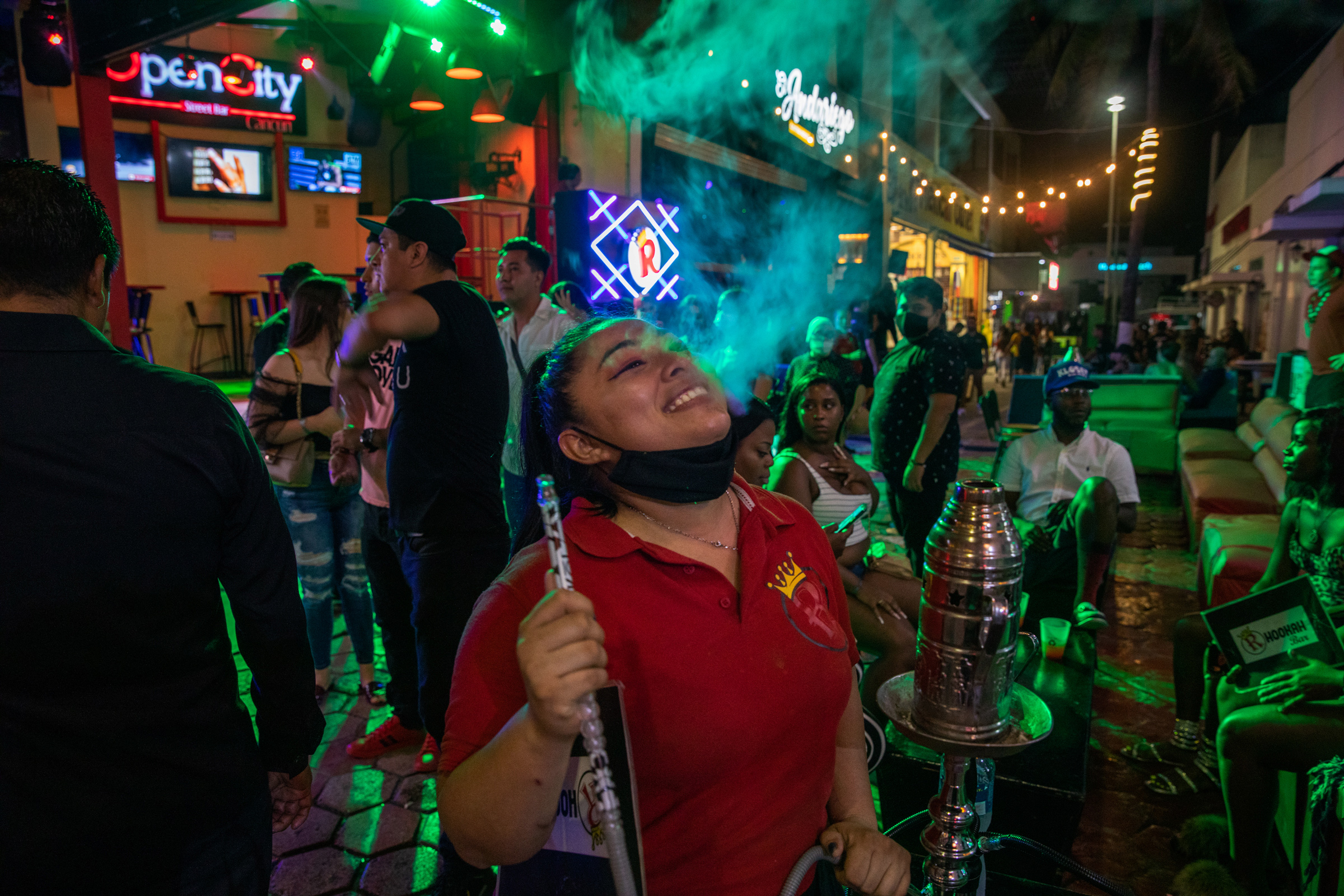 Tourists smoke hookah at local bars in the Cancún’s popular nightlife district on Oct. 17. After a drop in travel because of the pandemic, American tourists are again flooding the city’s streets and beaches. (Claudia Guadarrama—Magnum Foundation for TIME)