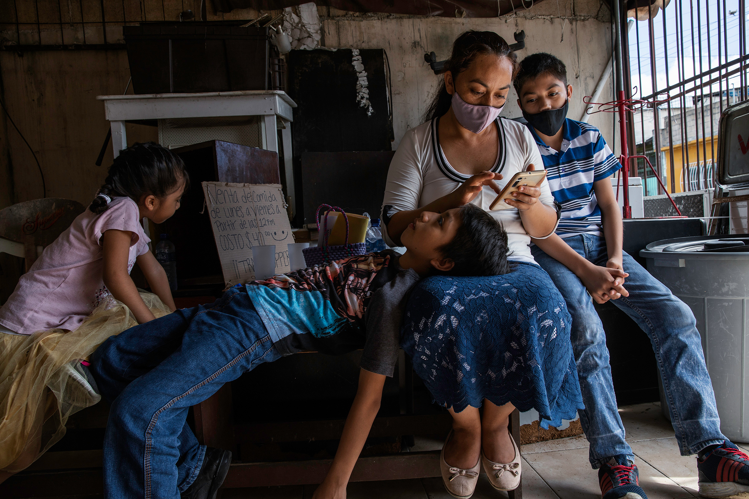 Magali, 35, and her sons wait outside Huellas de Pan Association, a a nonprofit working on food security, before a healthy-nutrition workshop in one of the poorest neighborhoods in Cancún. (Claudia Guadarrama—Magnum Foundation for TIME)