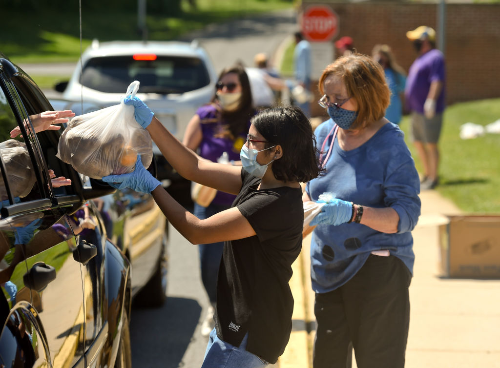 People receive bags of food at a drive-through food distribution event in Cumru, Penn. on May 30.