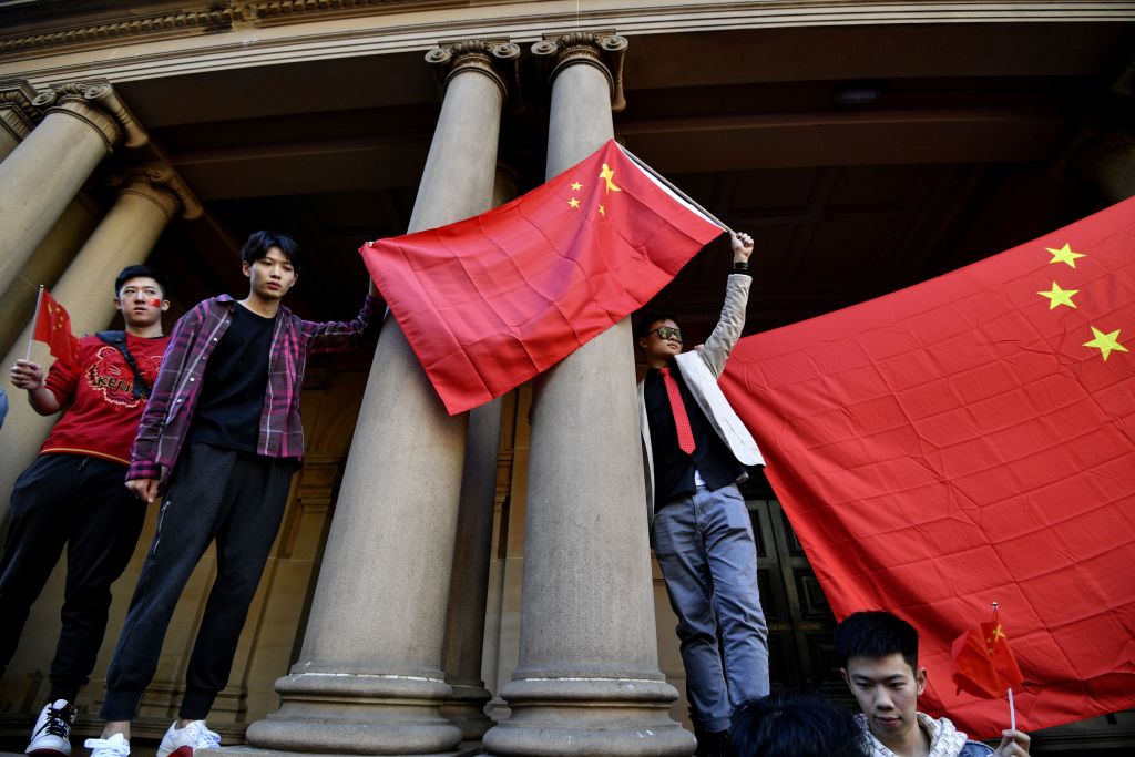 Pro-China activists hold up their national flag in Sydney on August 17, 2019, as they rally against ongoing protests in Hong Kong. (SAEED KHAN/AFP via Getty Images)