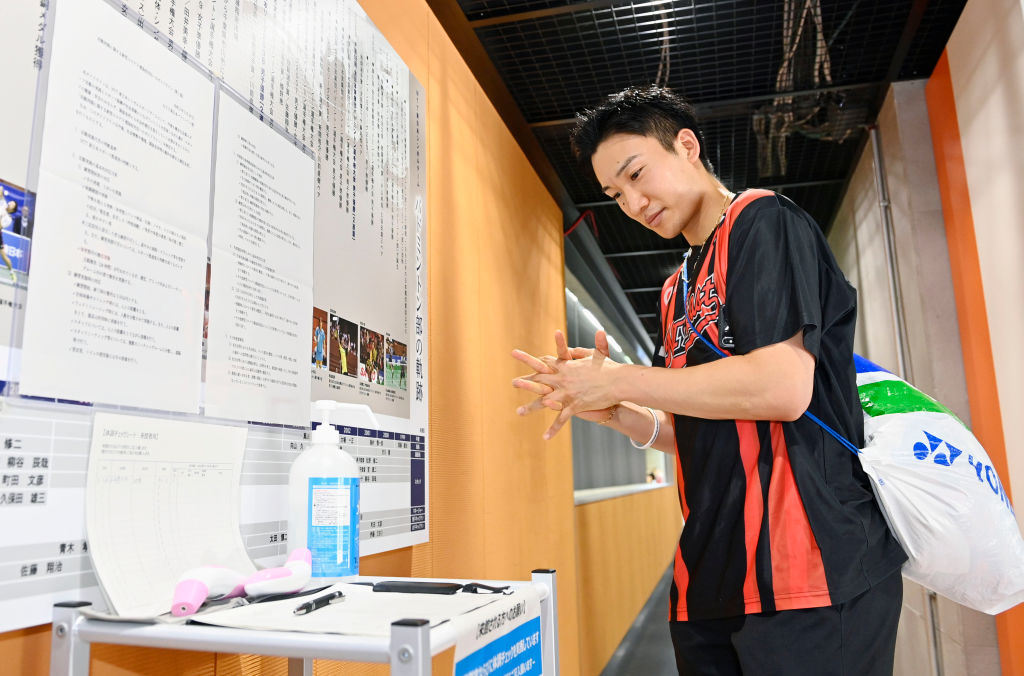 Japan's badminton player Kento Momota disinfects his hands prior to a training session in Tokyo on June 26, 2020. He has vowed to bring home Gold at the postponed Tokyo Games. (Yohei Nishimura / POOL / AFP via Getty Images)
