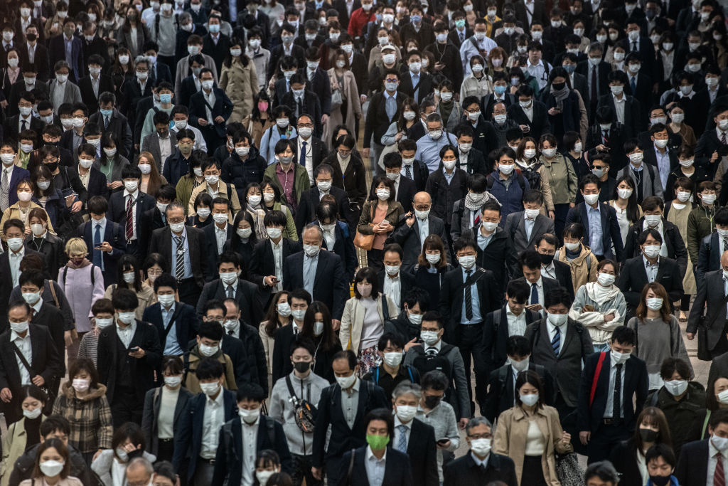 Commuters, mostly wearing face masks, walk through Shinagawa train station on November 18, 2020 in Tokyo, Japan. (Carl Court/Getty Images)