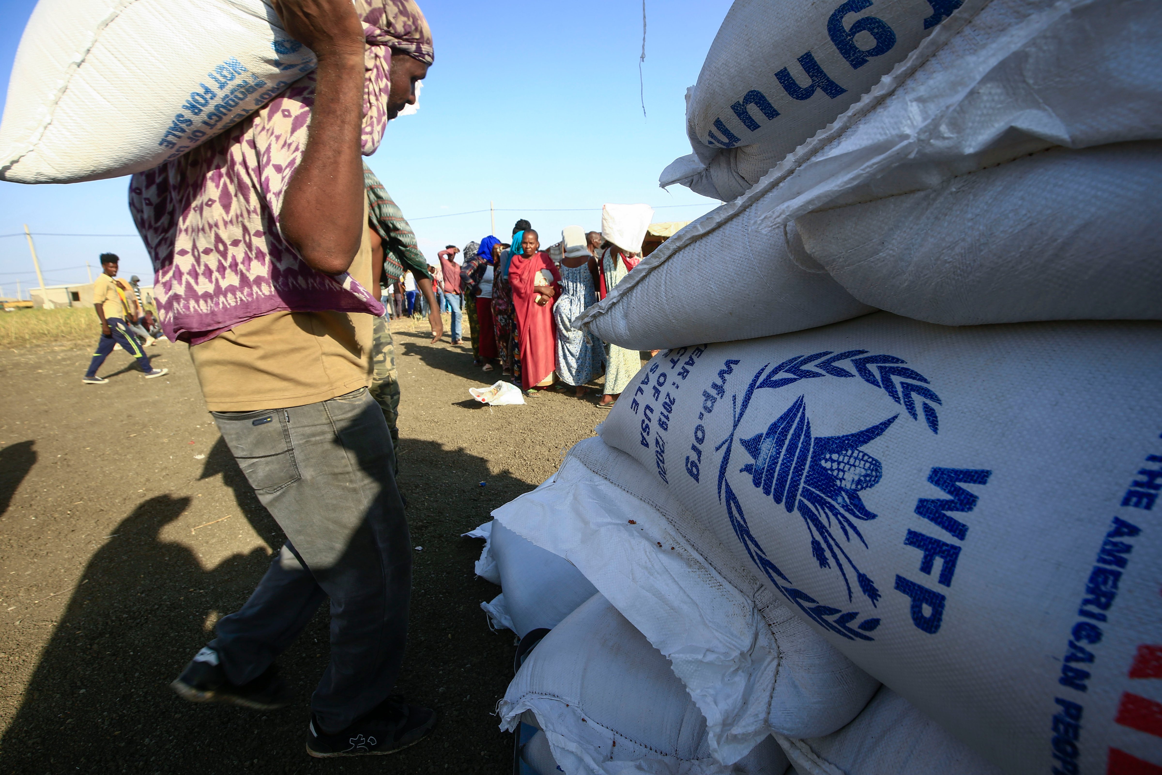 Ethiopian refugees who fled fighting in the Tigray Region watch workers unload World Food Programme food aid at the Village 8 border reception center in Sudan's eastern Gedaref State, on November 20, 2020. (Ashraf Shazly—AFP/ Getty Images)
