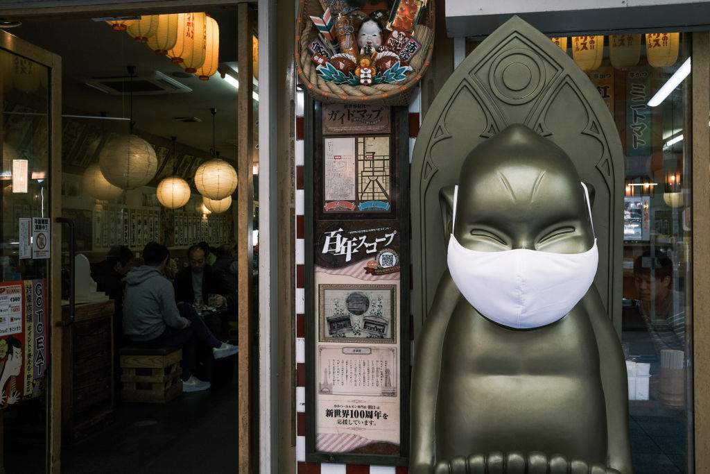 A statue in front of a restaurant wears a protective mask in the Shinsekai shopping district of Osaka, Japan, on Sunday, Nov. 29, 2020. (Soichiro Koriyama/Bloomberg via Getty Images)