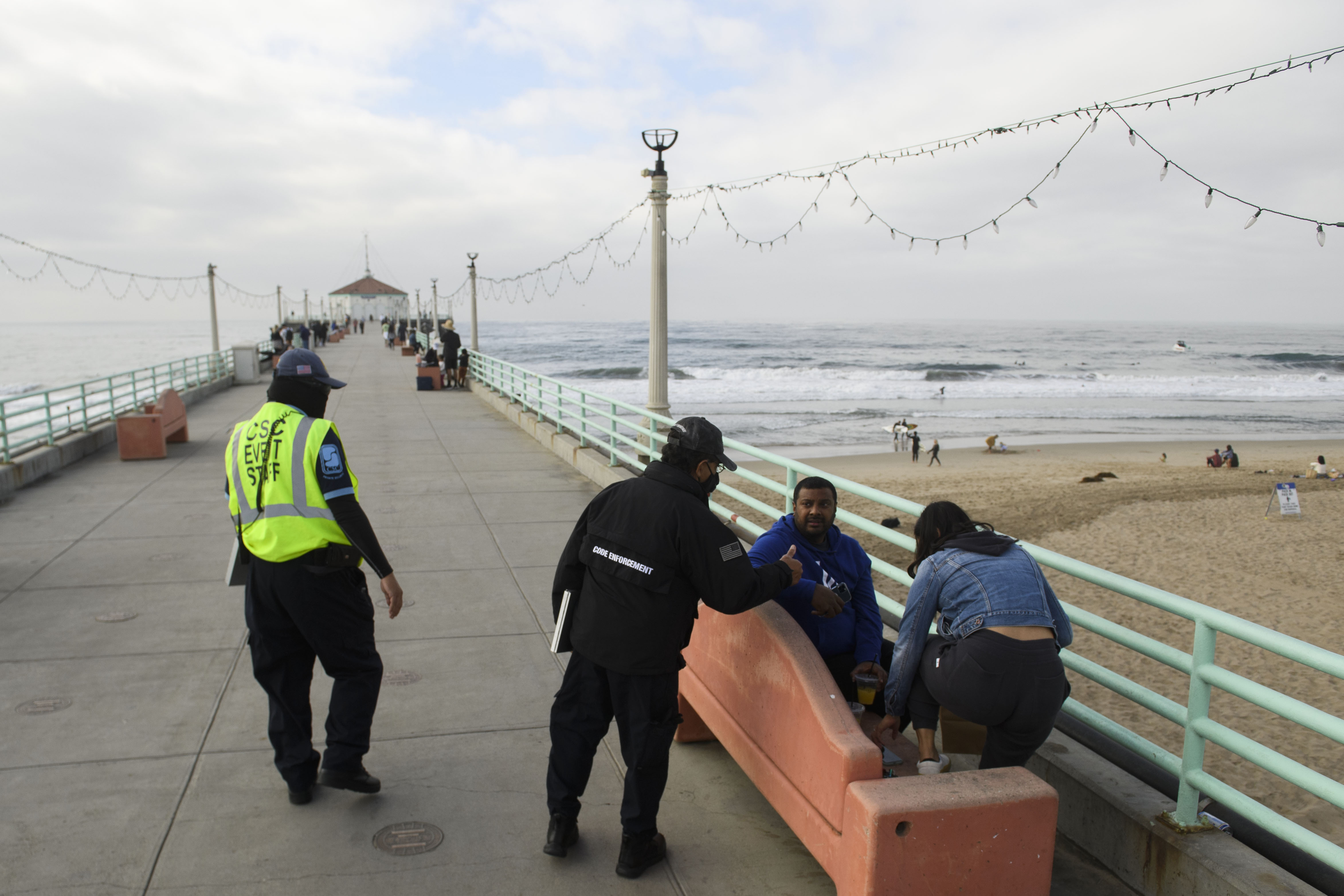 City workers enforce COVID-19 mask restrictions on the pier in Manhattan Beach, Calif., on Dec. 12, 2020. (Patrick T. Fallon—AFP/Getty Images)